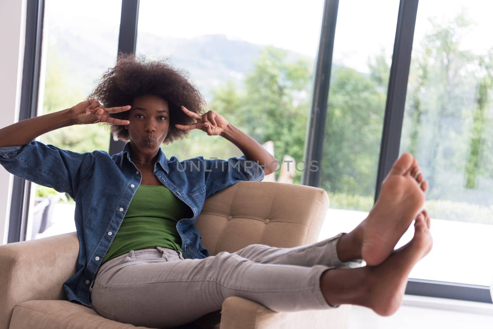 Young african american woman at home in the chair relaxing in her luxury home