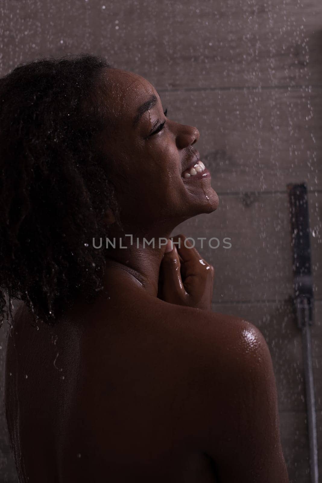 Woman in the shower,beautiful black young female showering under refreshing water, healthy lifestyle, enjoying time in luxury spa resort
