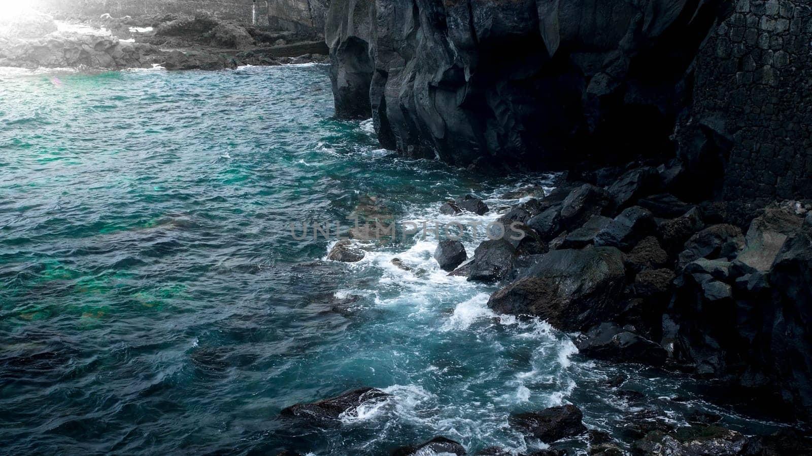 High black volcanic cliffs and rockes on the ocean coast.