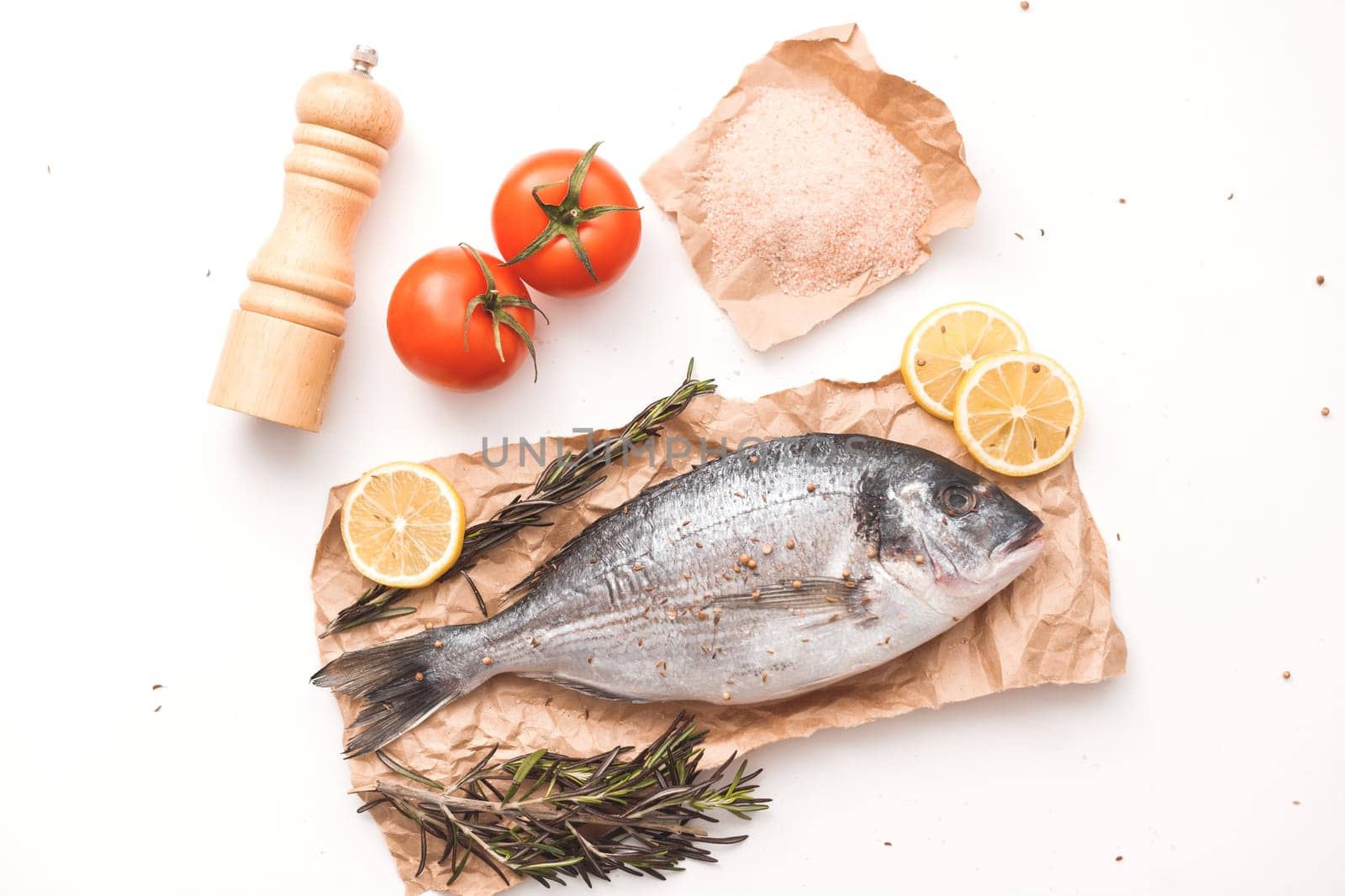 Raw dorada fish or gilt-head bream over white background, flat lay, top view.