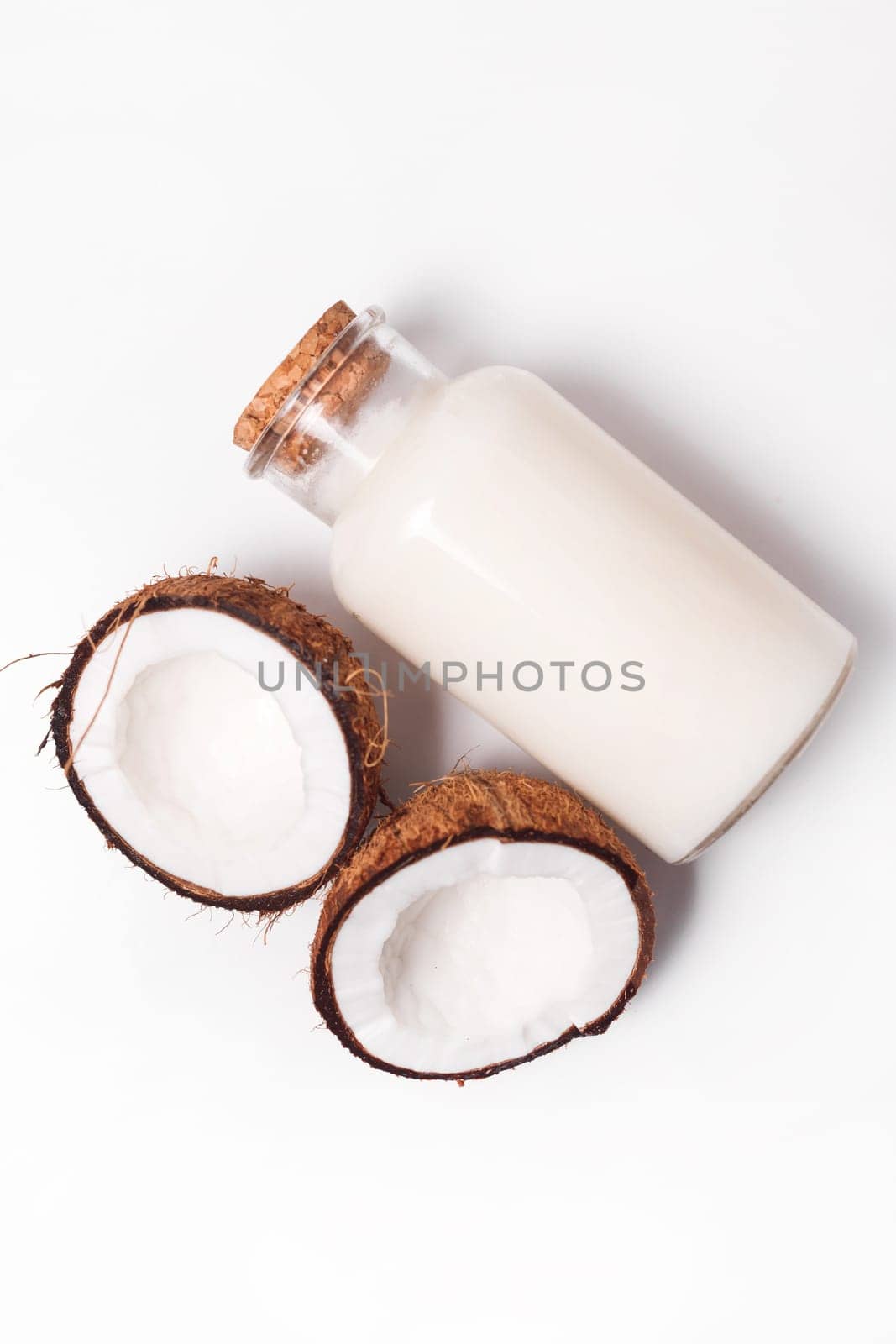 Top view organic coconut butter with fresh coconut pieces over white background.