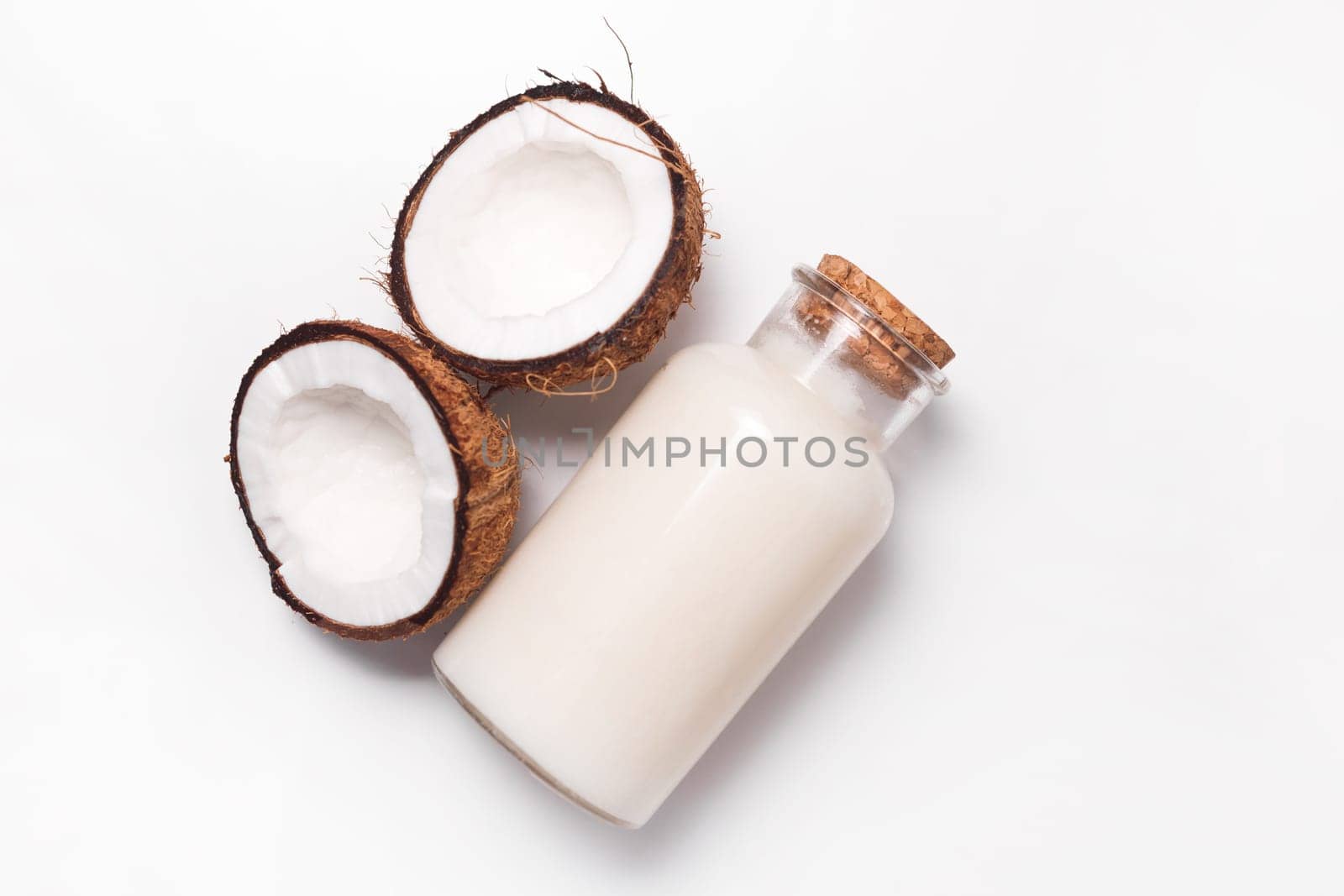 Top view organic coconut butter with fresh coconut pieces over white background.