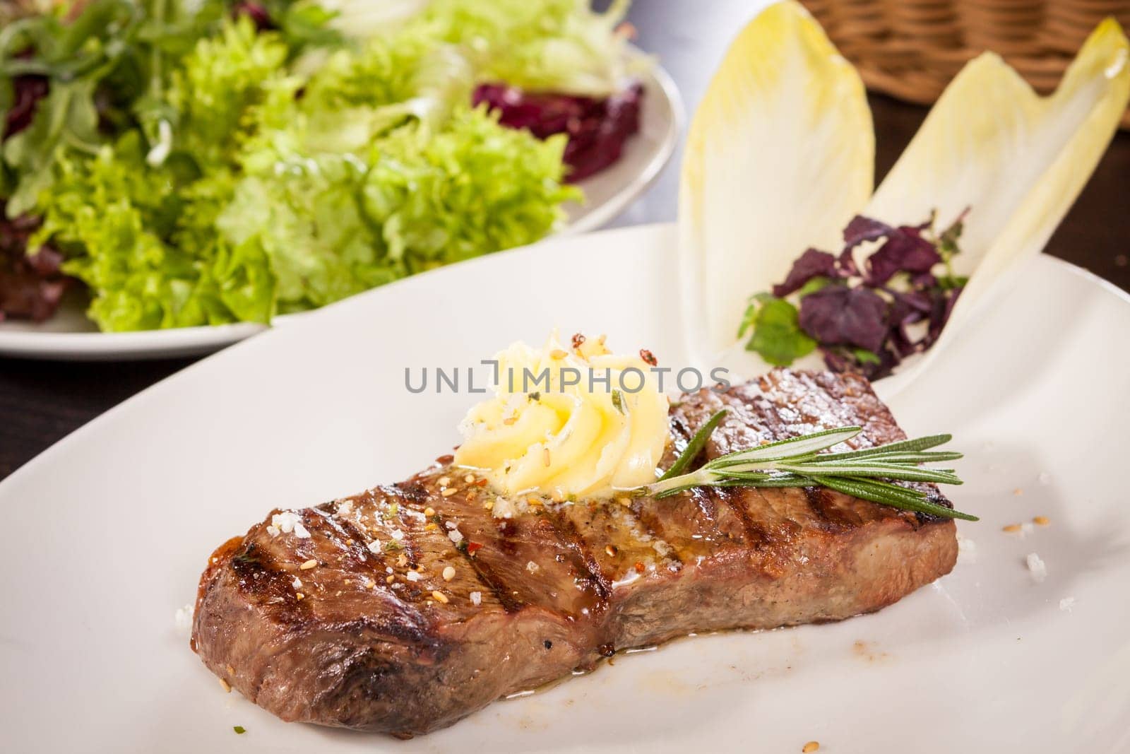 Succulent grilled beef fillet steak with homemade herb butter on a plate
