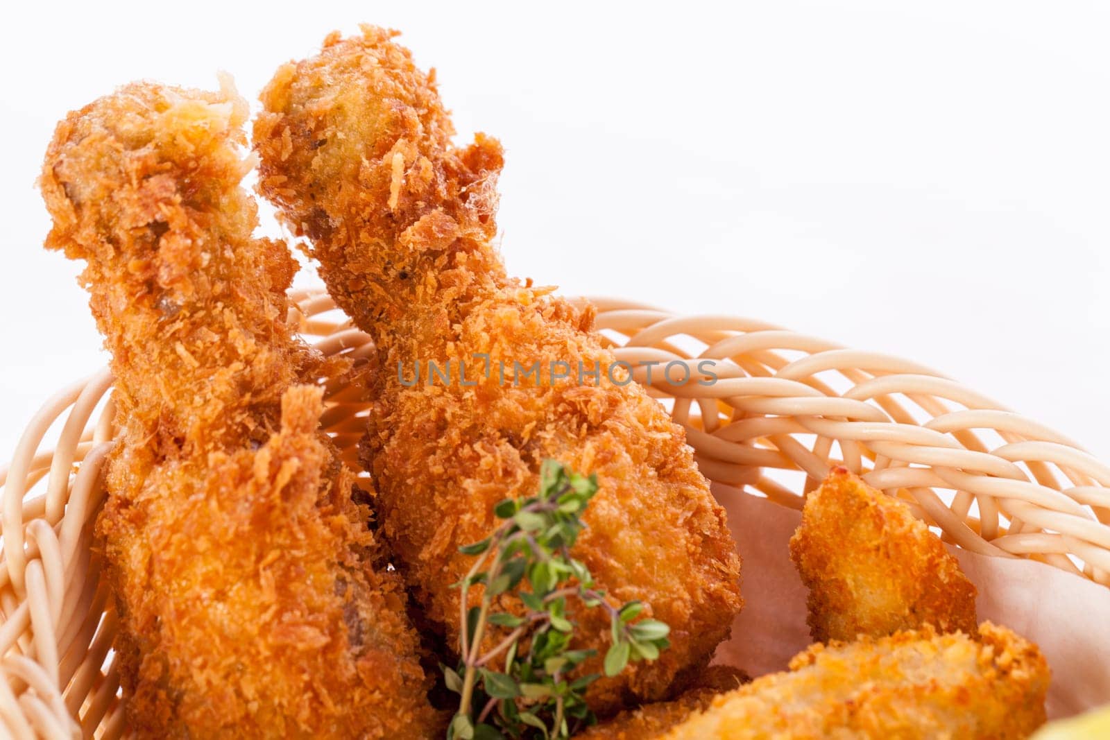 Crispy fried chicken wings with a dip on a plate insulated against a white background