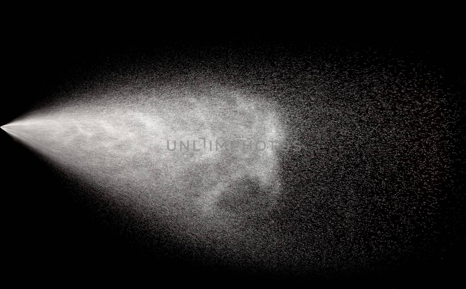 Spraying of water in motion on black background.