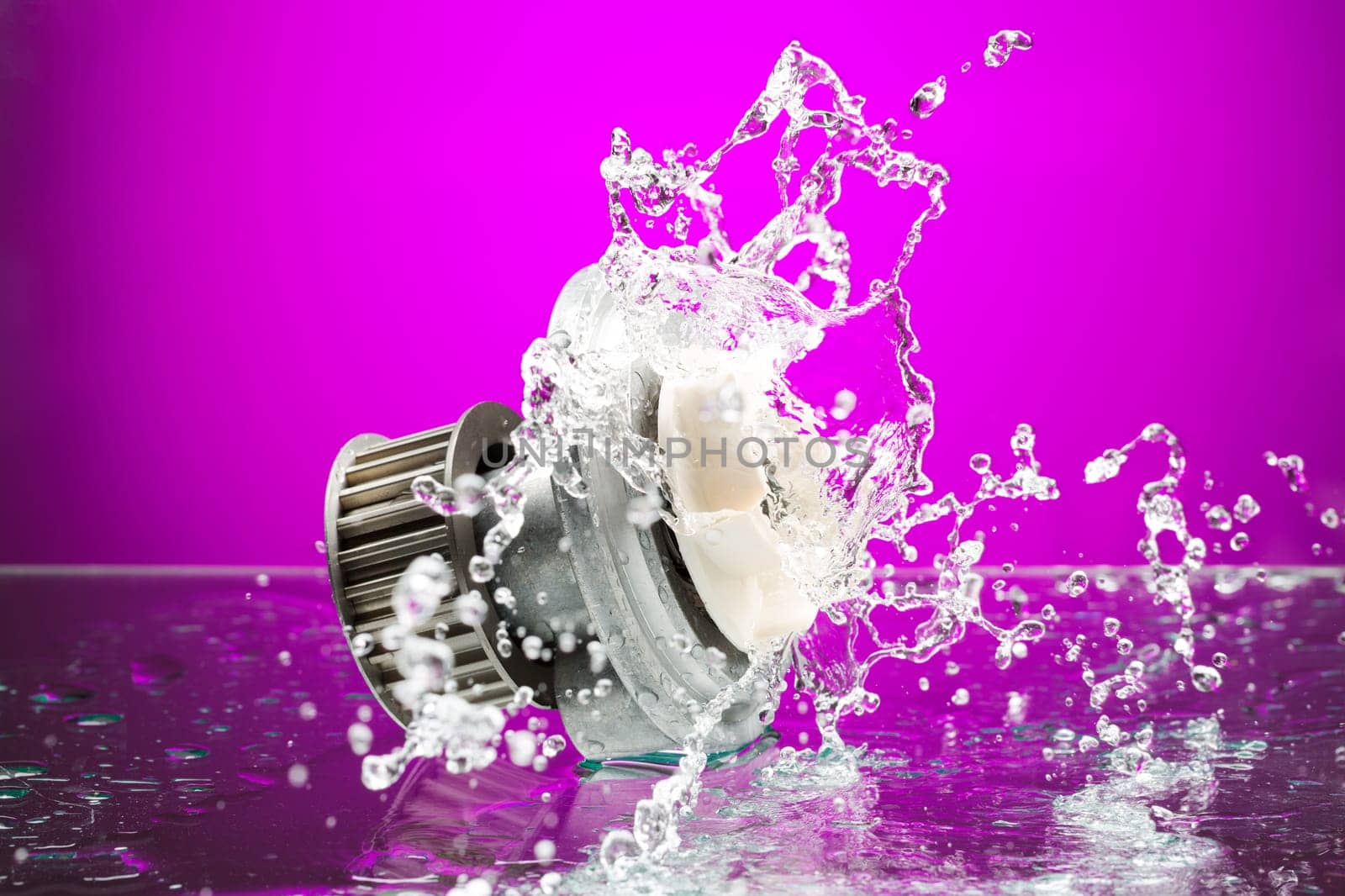 Auto parts, engine cooling pump in spurts of water on purple gradient background