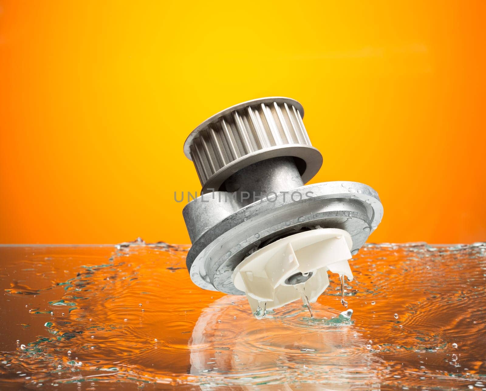 Auto parts, engine cooling pump in water splash on orange gradient background.
