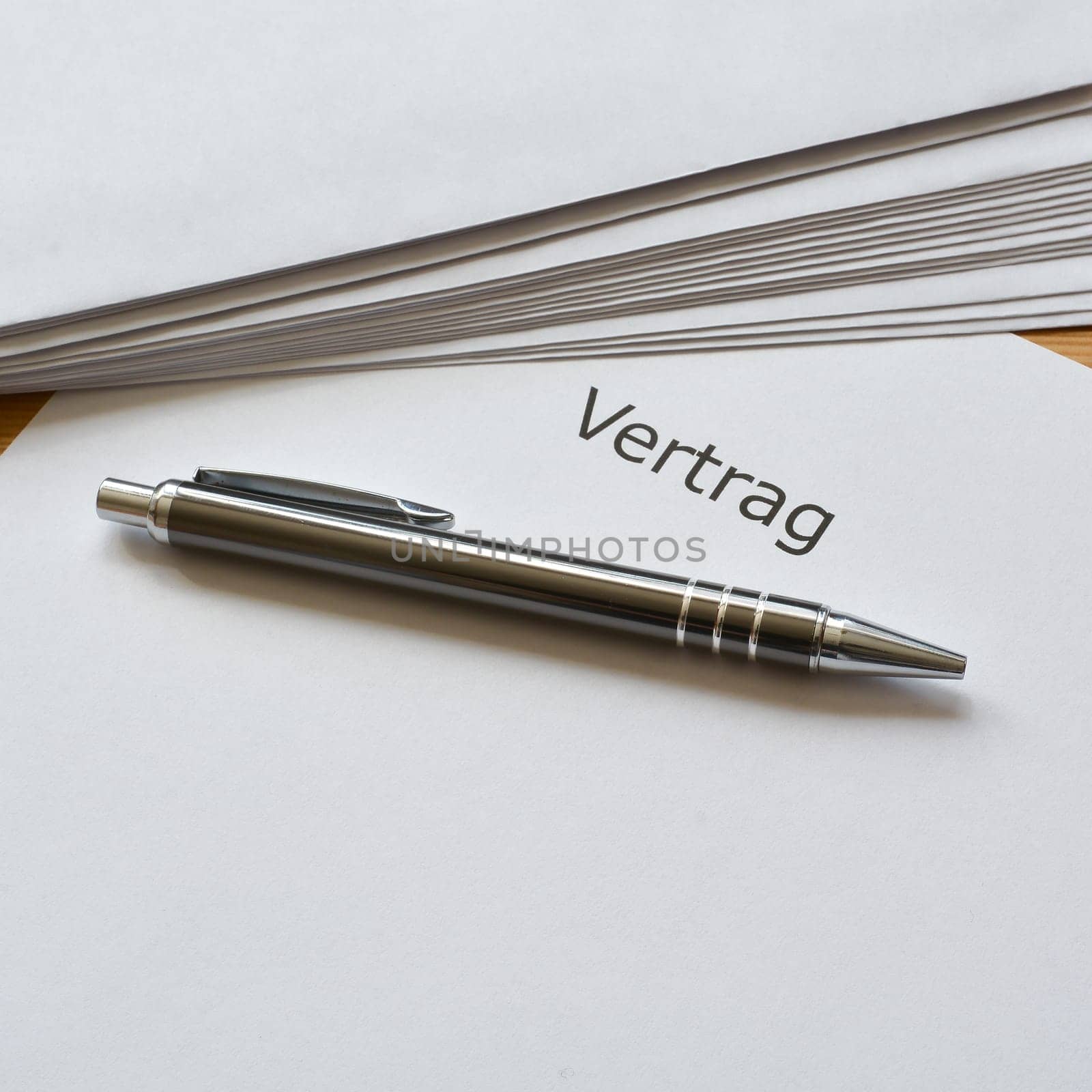 Contract and ballpoint pen are on a desk