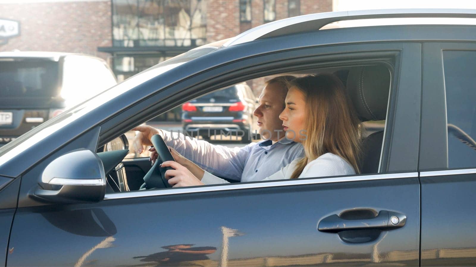 Portrait of young man showing the correct route to his wife driving a car.