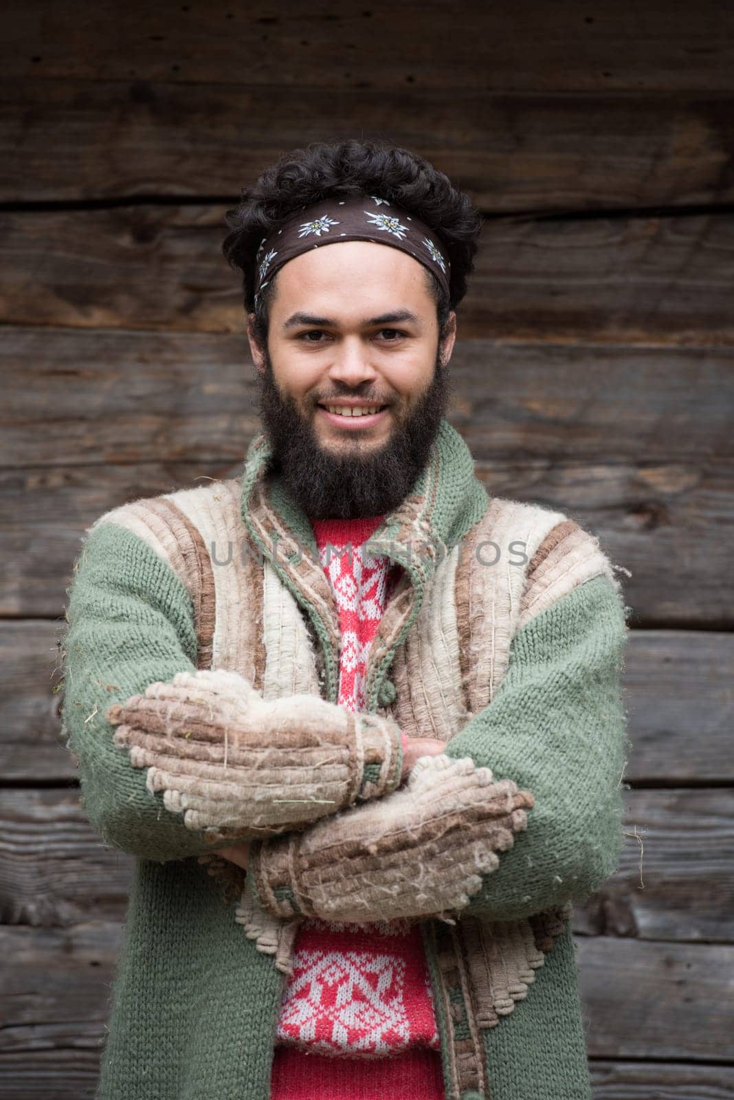 portrait of young hipster,  man with beard in front of old vintage wooden house