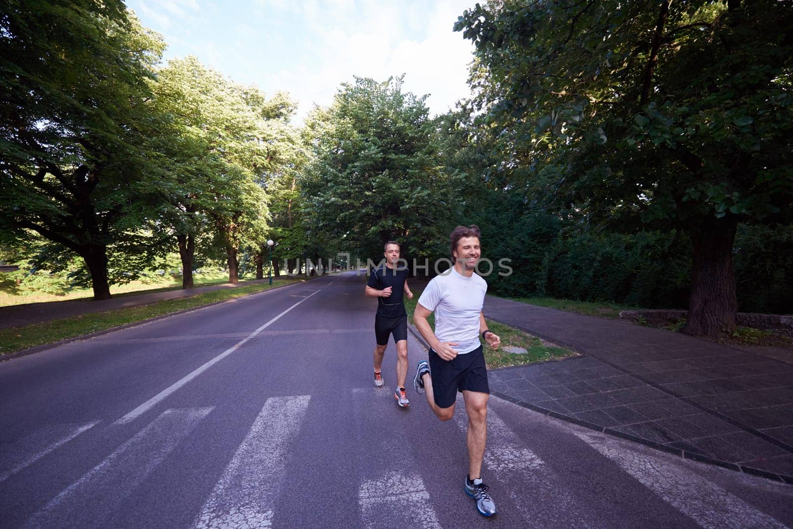 healthy athlete man jogging at morning on empty  roat in the city