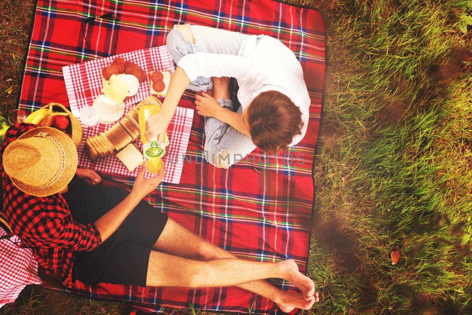 Couple in love enjoying picnic time drink and food in beautiful nature on the river bank top view