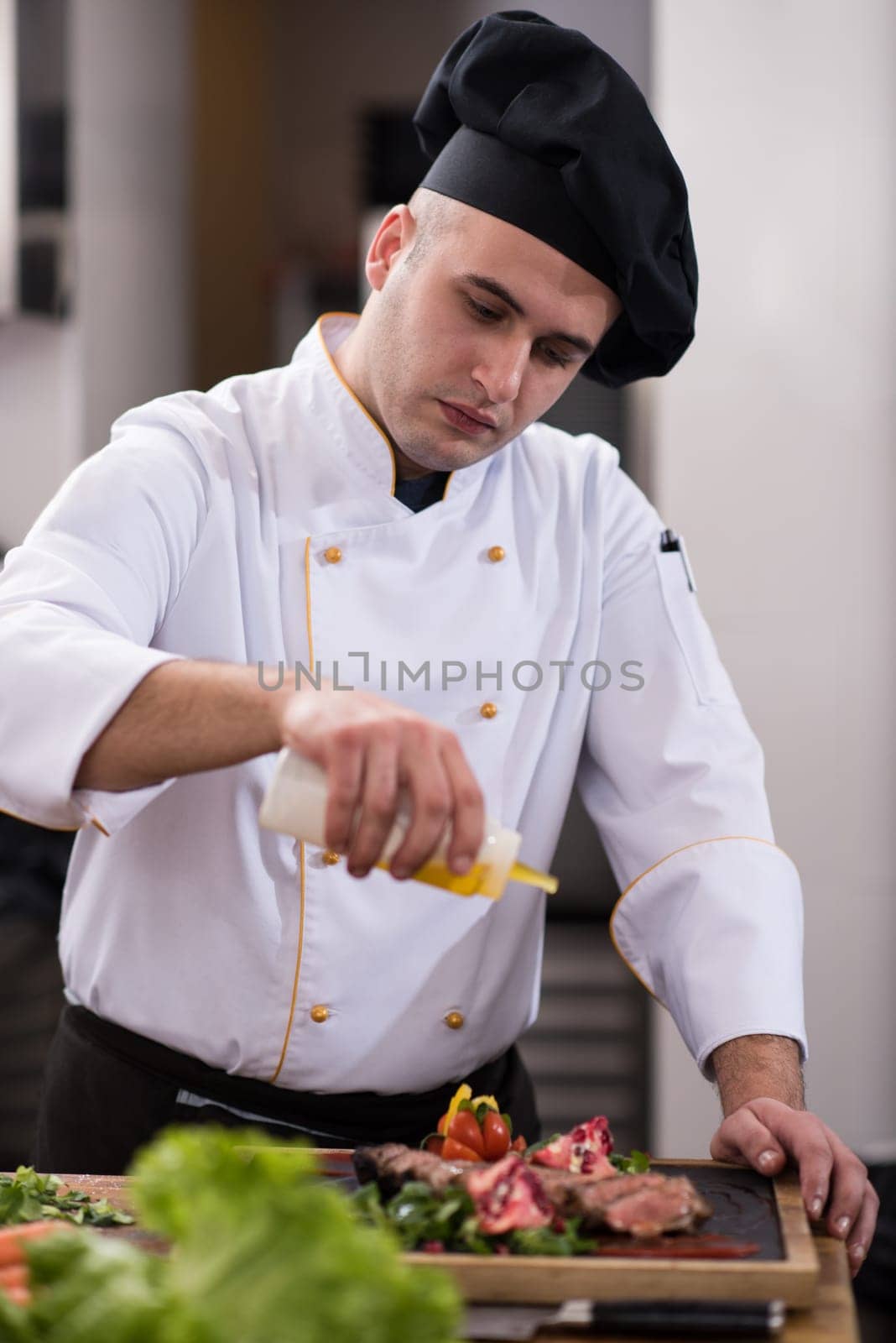 Chef finishing steak meat plate with Finally dish dressing and almost ready to serve at the table