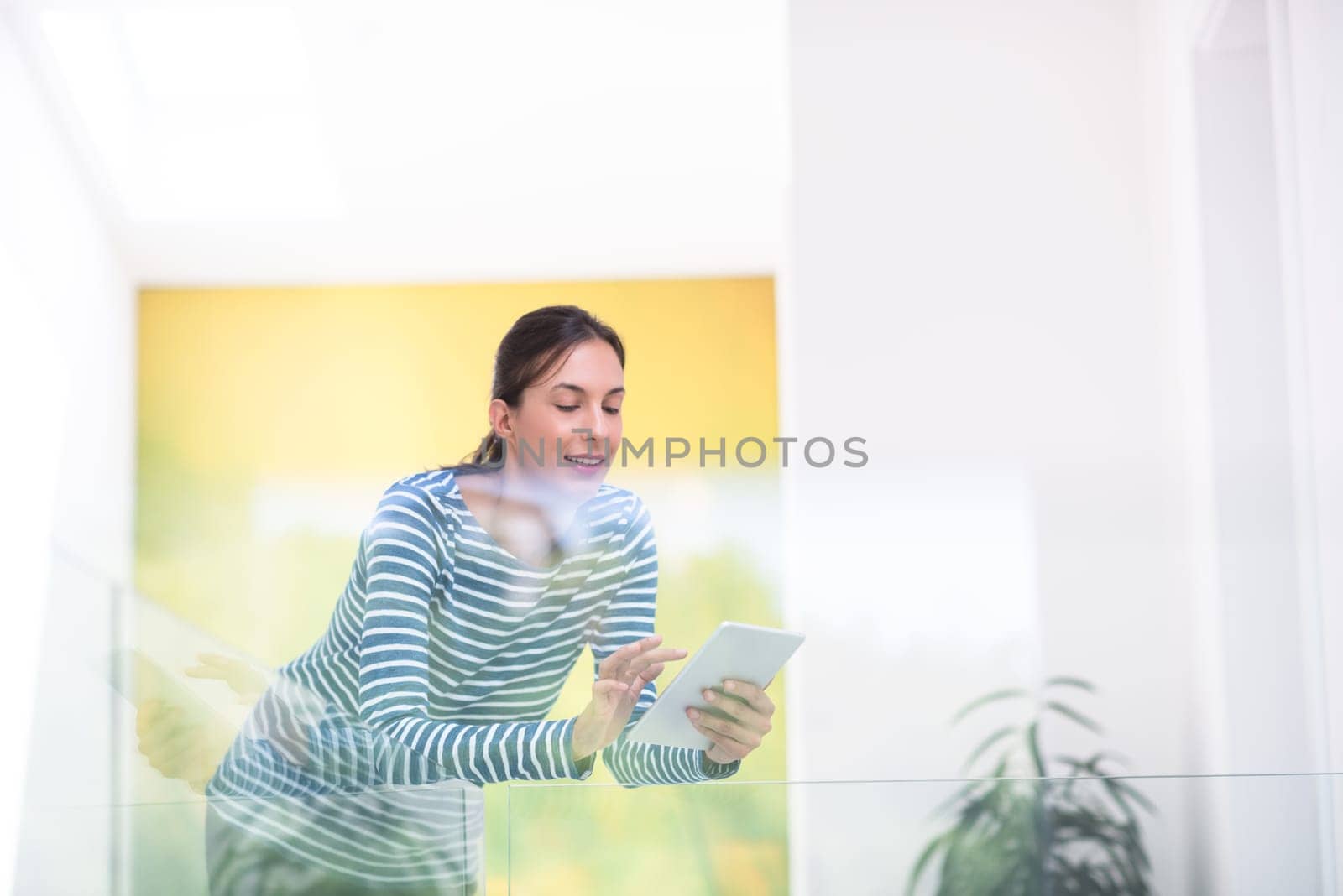 beautiful young woman at home websurfing on internet with tablet