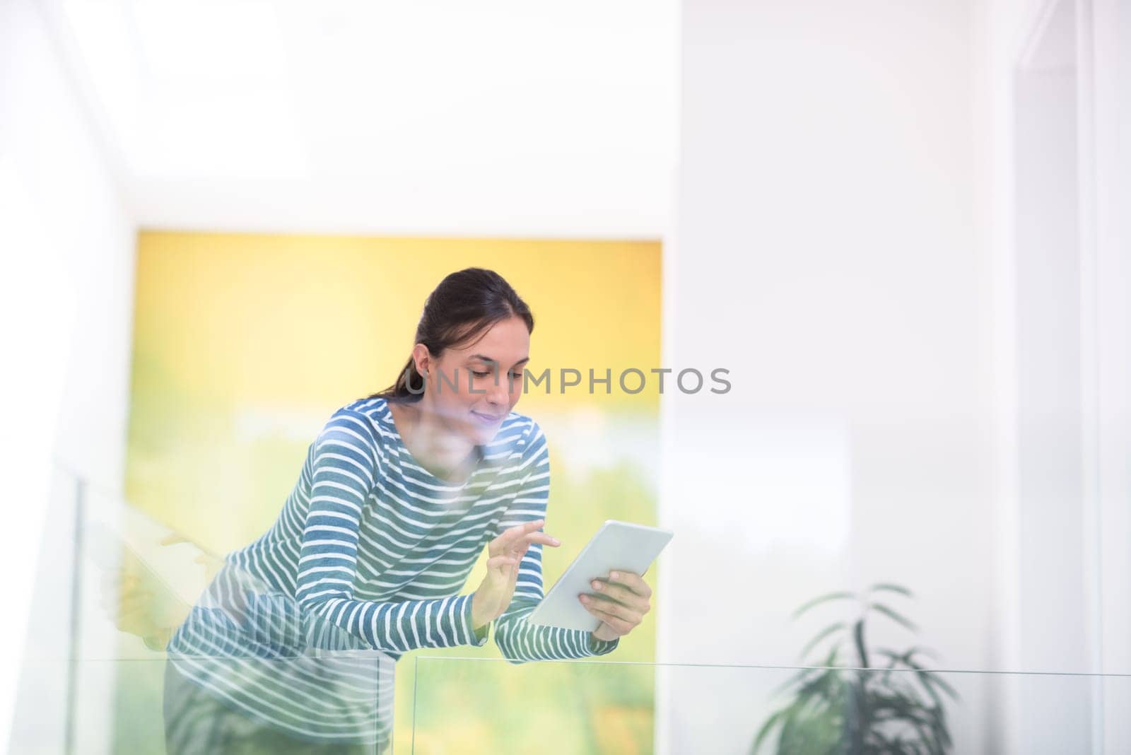 beautiful young woman at home websurfing on internet with tablet
