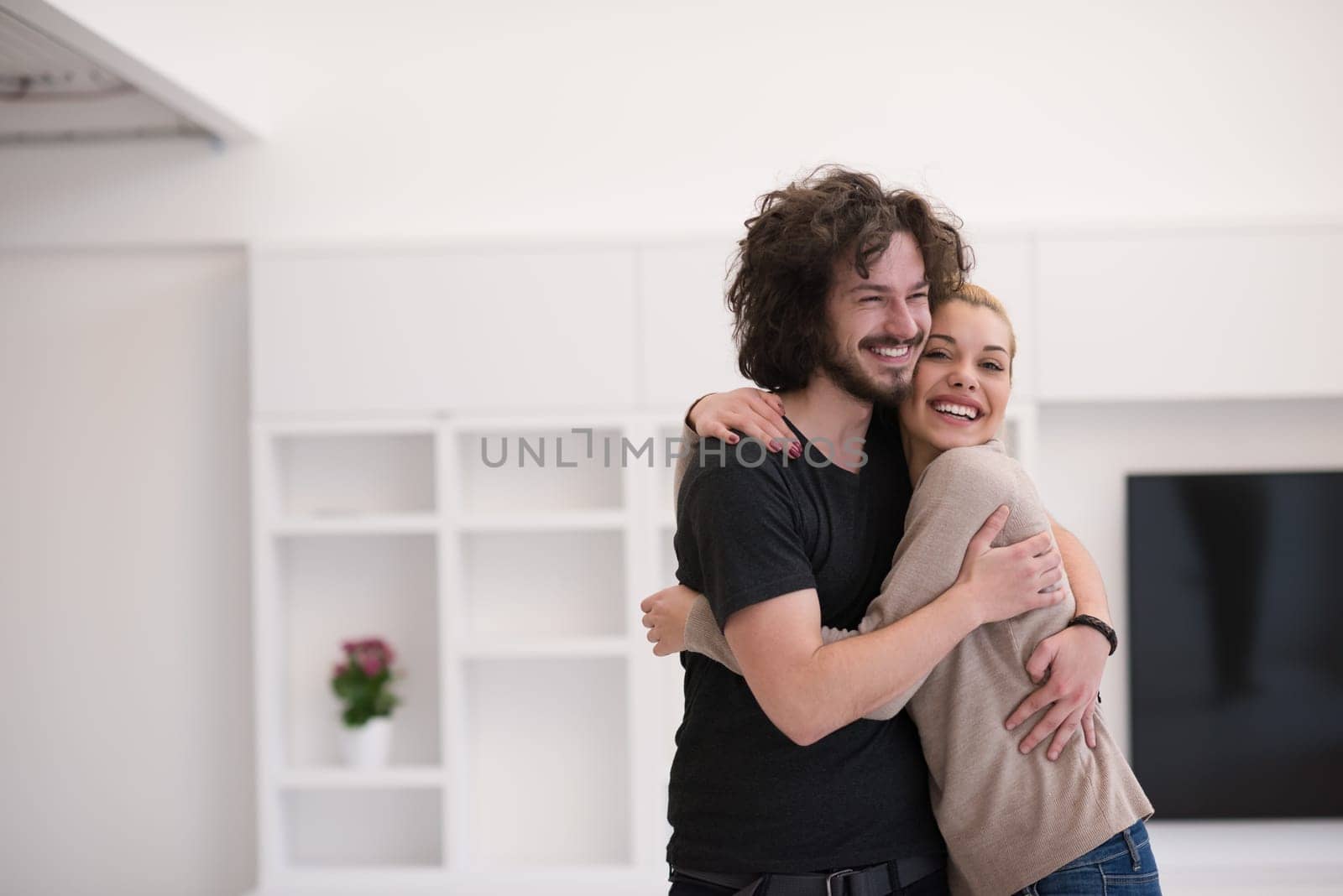 Portrait of a happy young beautiful couple hugging in their new home