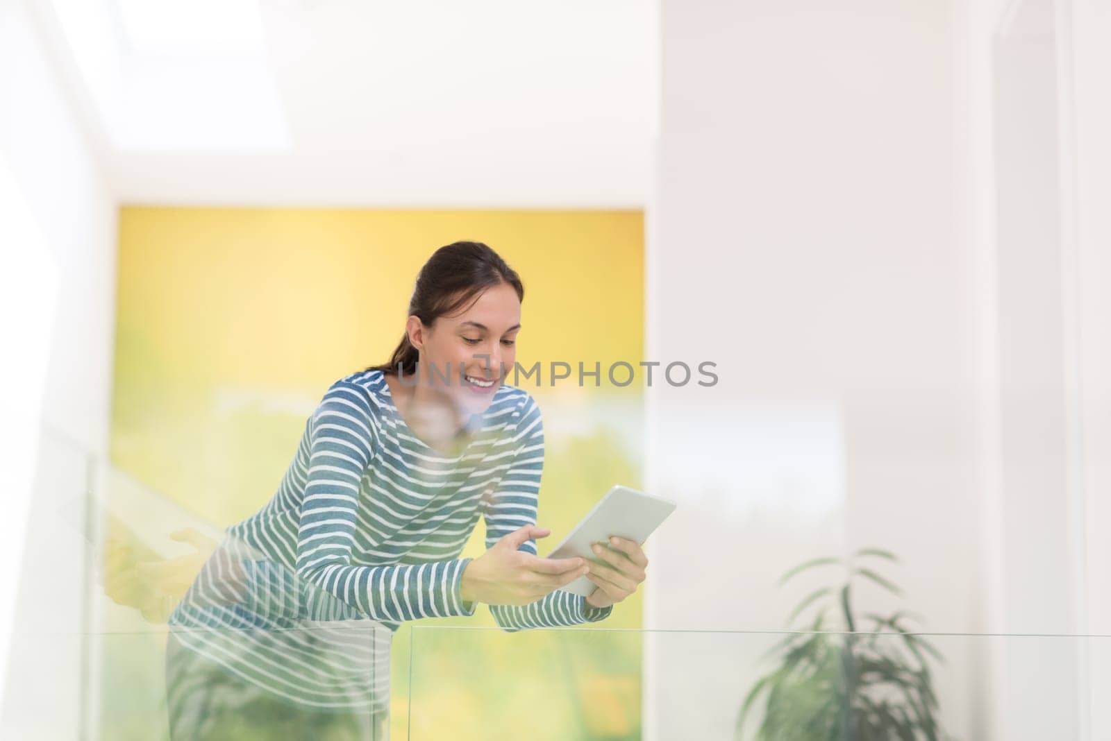 beautiful young woman at home websurfing on internet with tablet