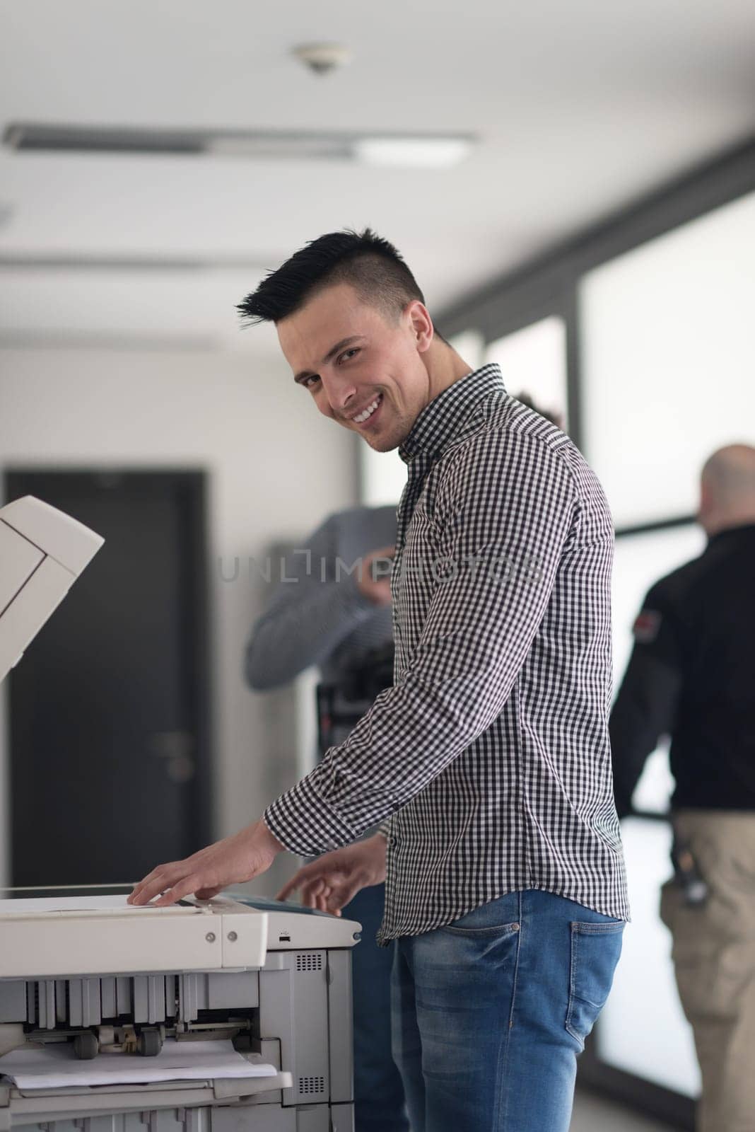 young business man copy documents on copy machine at modern startup office interior, casual clothes