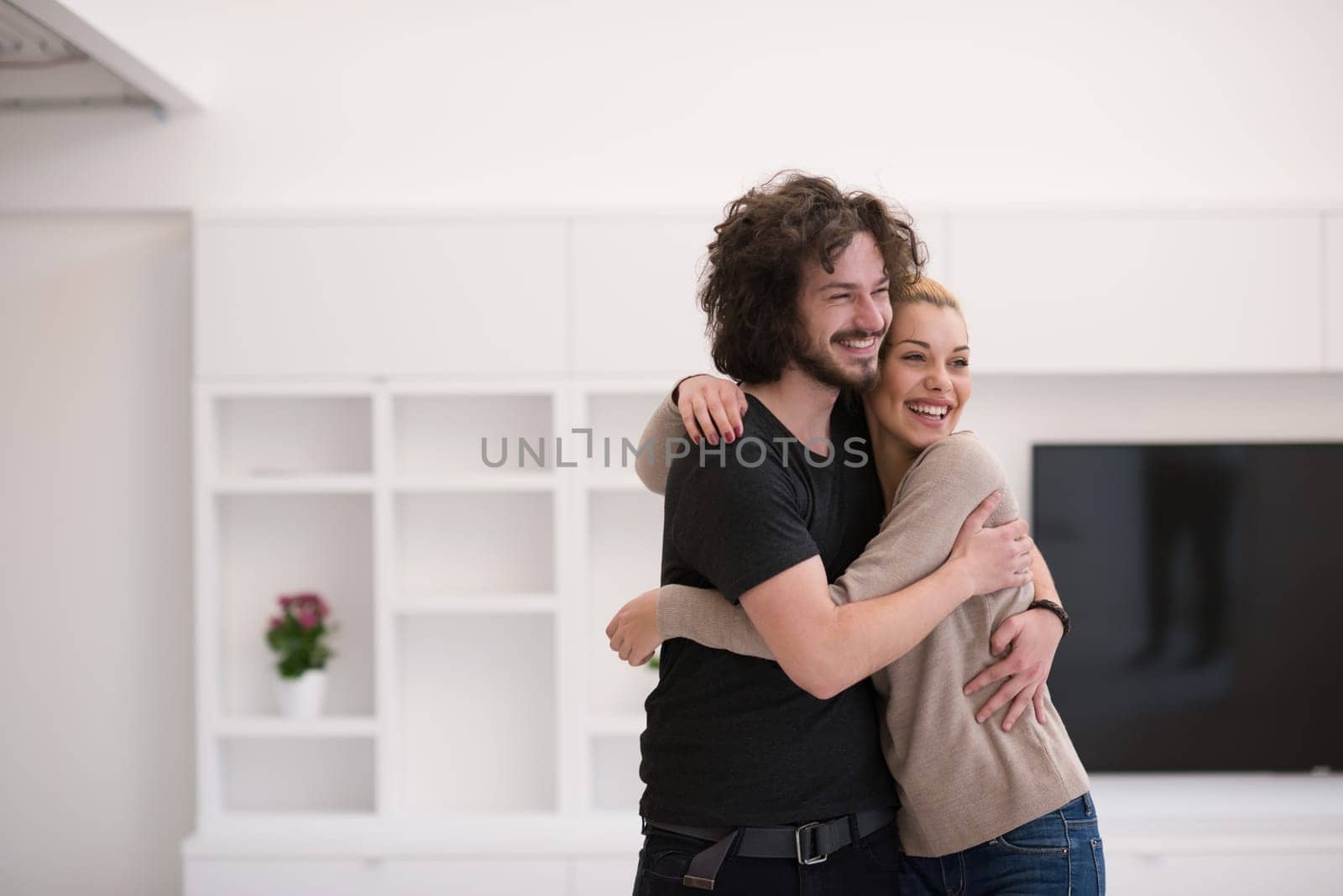 Portrait of a happy young beautiful couple hugging in their new home