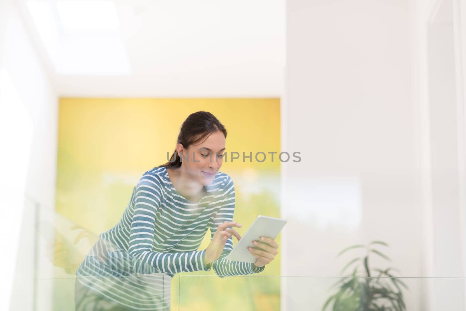beautiful young woman at home websurfing on internet with tablet