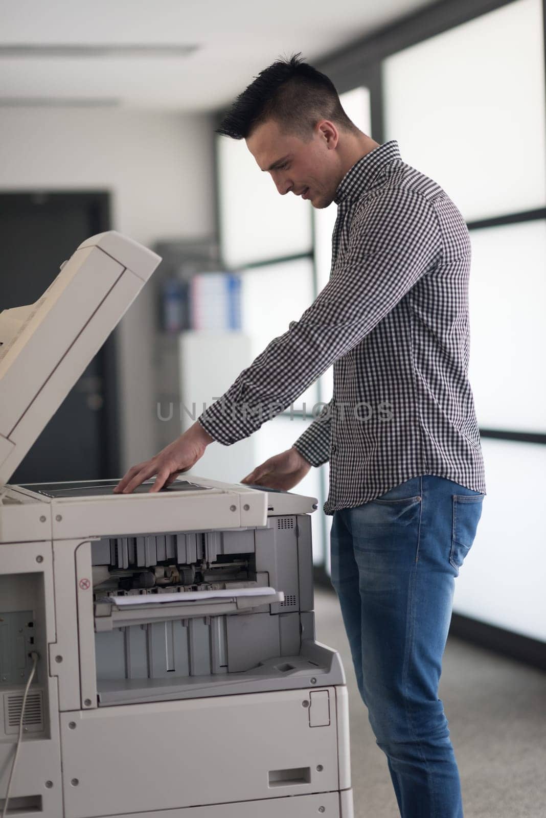 young business man copy documents on copy machine at modern startup office interior, casual clothes