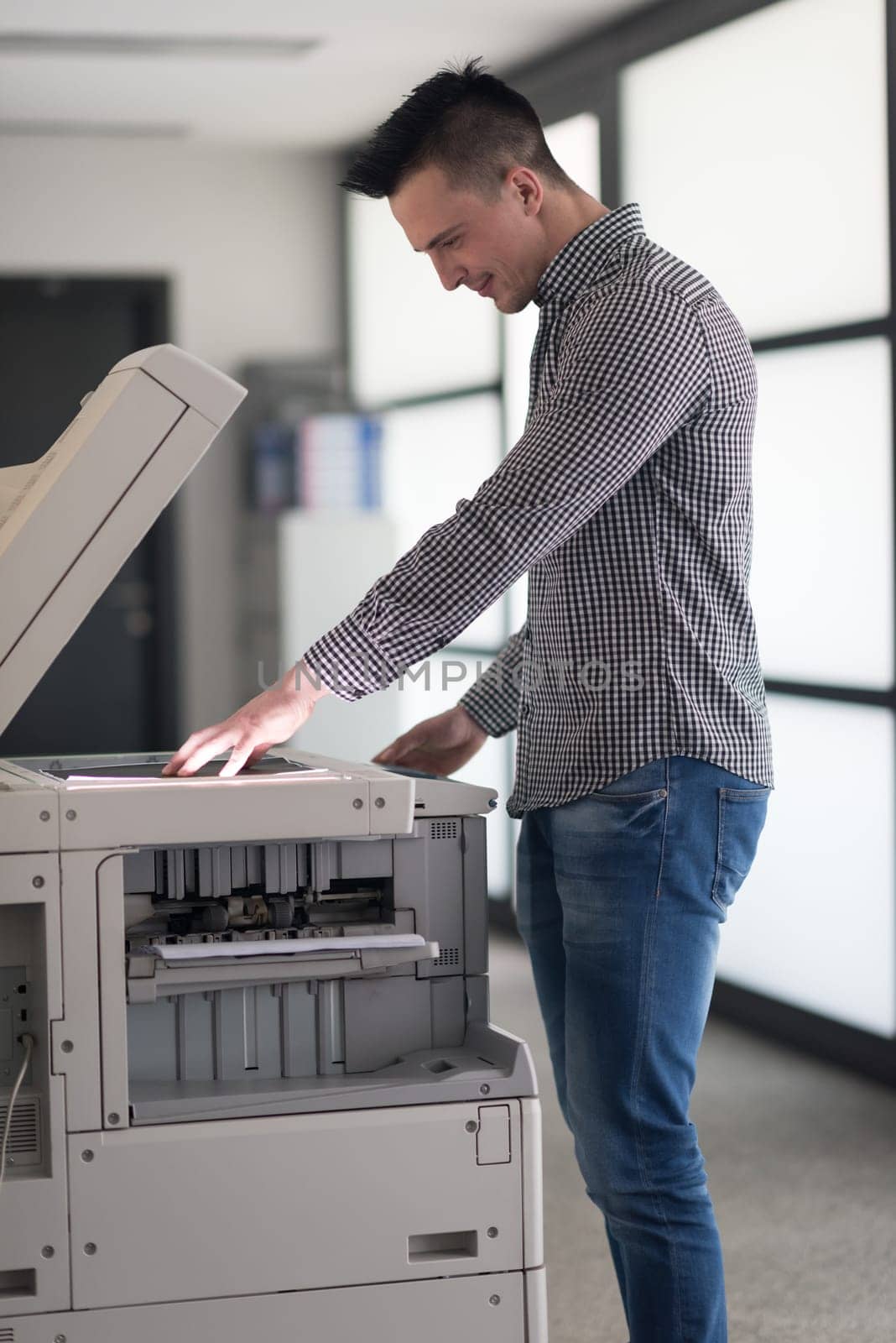 young business man copy documents on copy machine at modern startup office interior, casual clothes