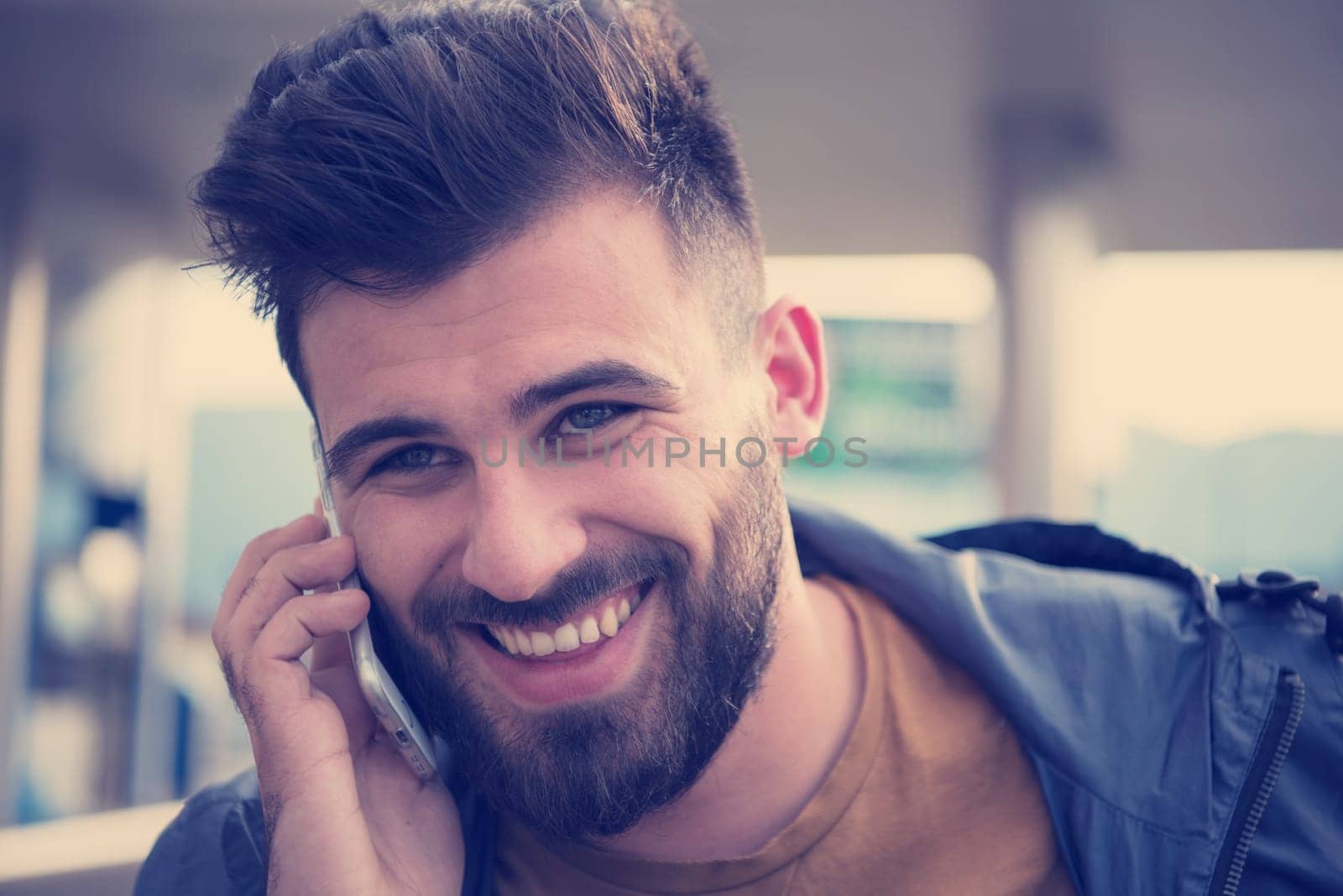 handsome young casual business man with beard using cell phone and smile outdoor on city street