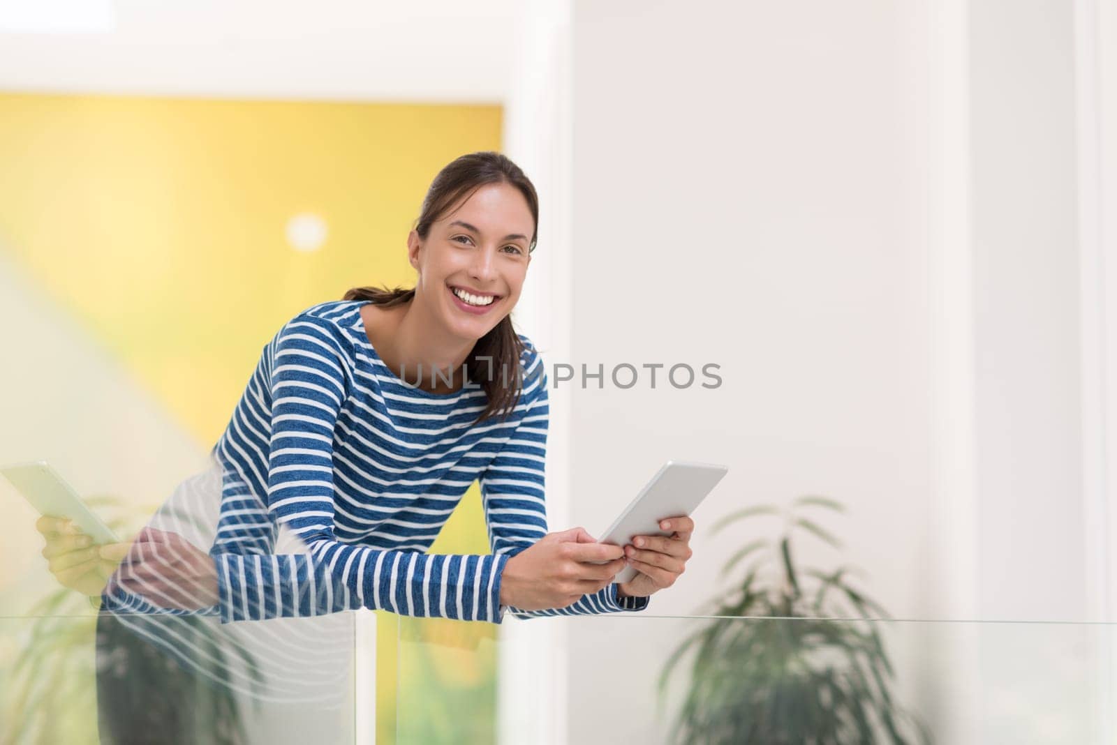 beautiful young woman at home websurfing on internet with tablet