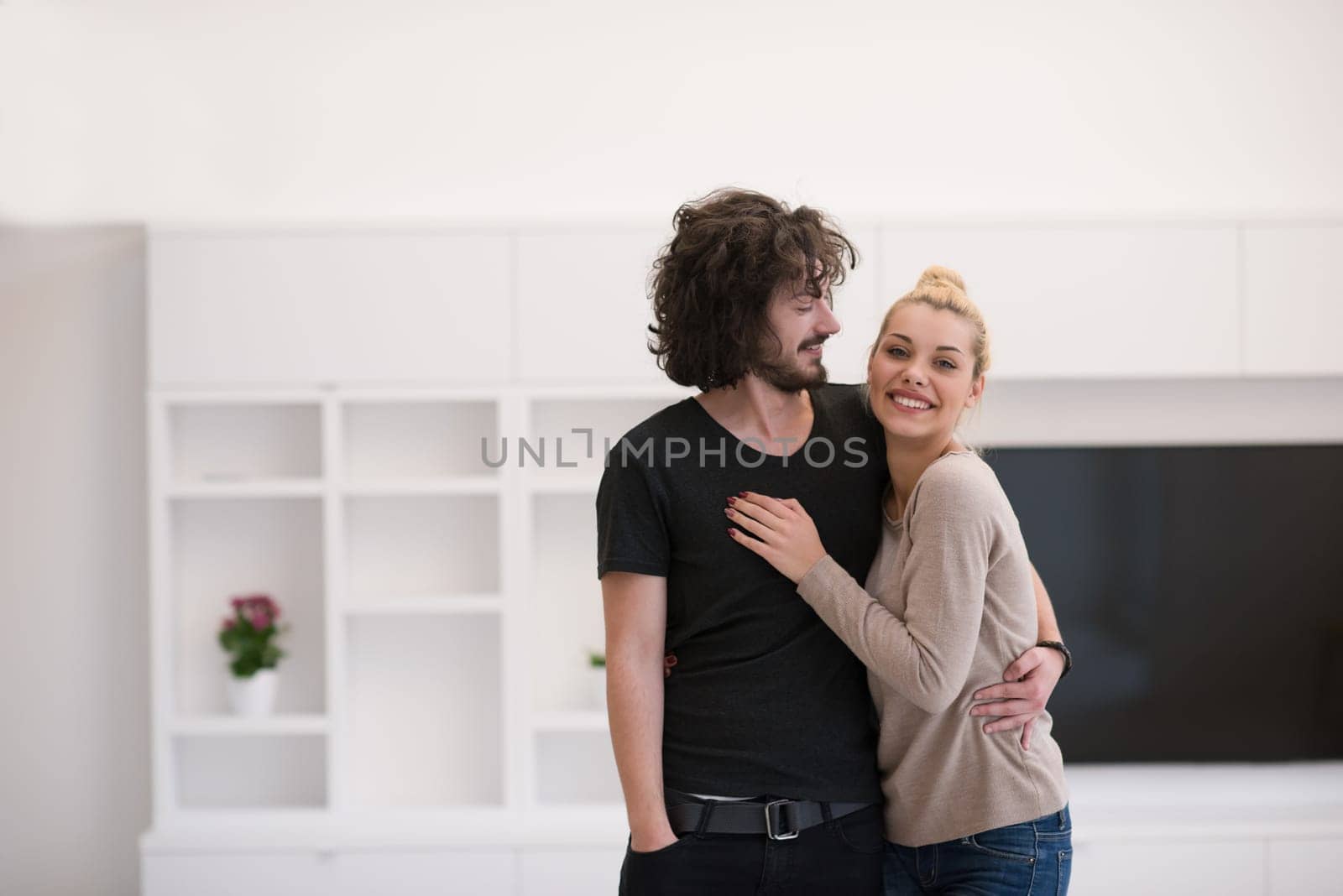 Portrait of a happy young beautiful couple hugging in their new home