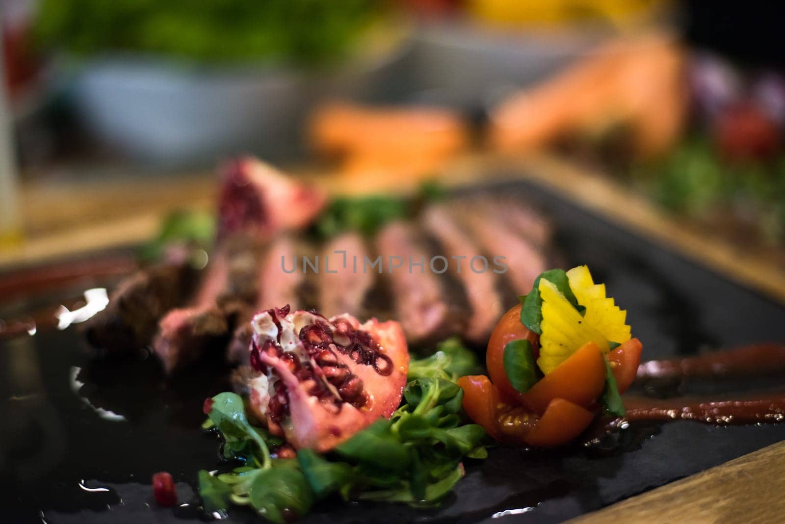Juicy slices of grilled steak  with vegetables on a wooden board