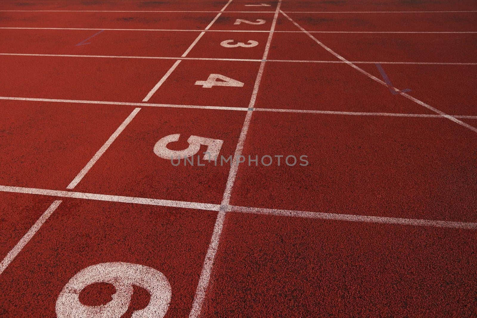 Red athletic track treadmill at the stadium with the numbering.