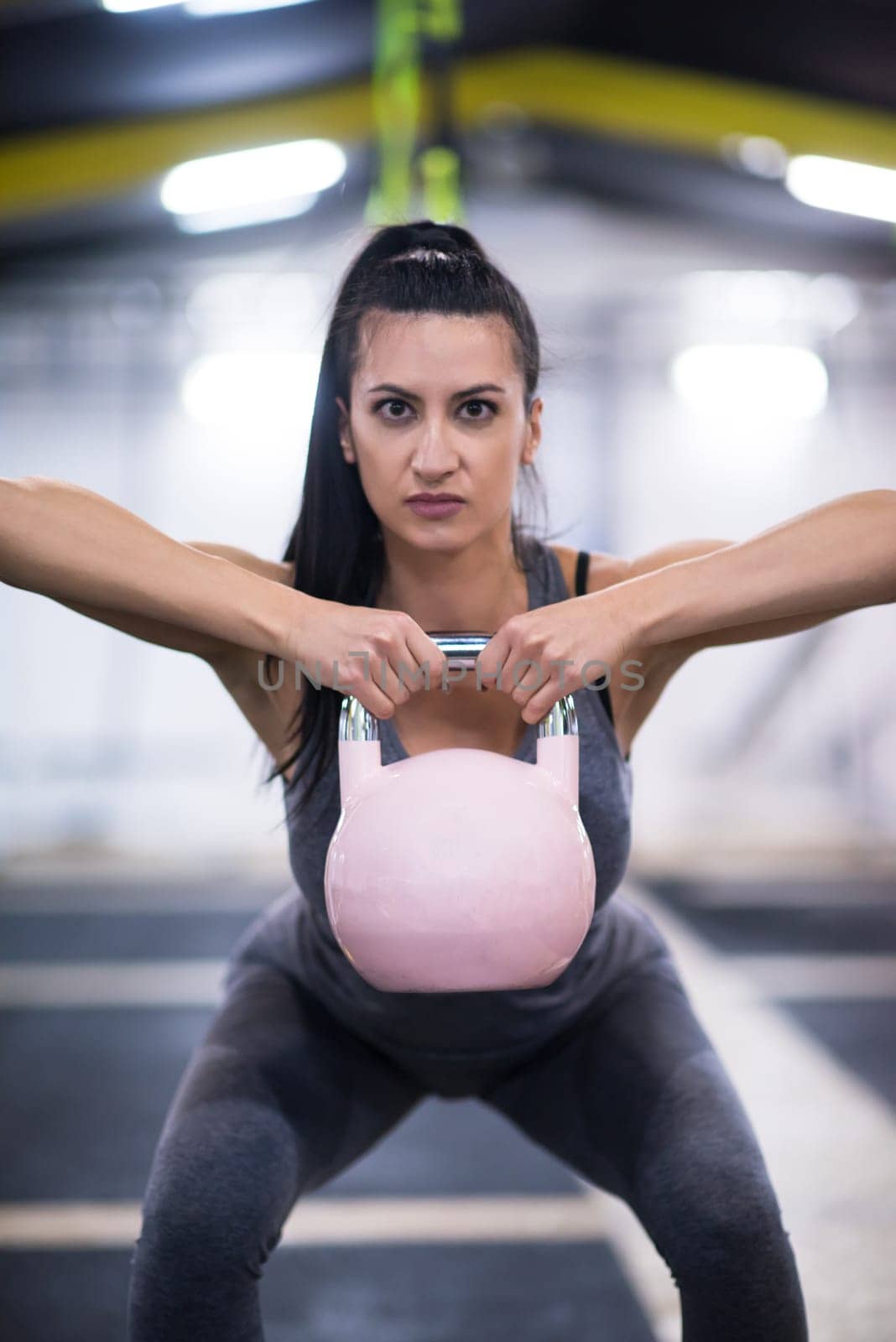young  woman athlete exercise with fitness kettlebell at cross fitness gym