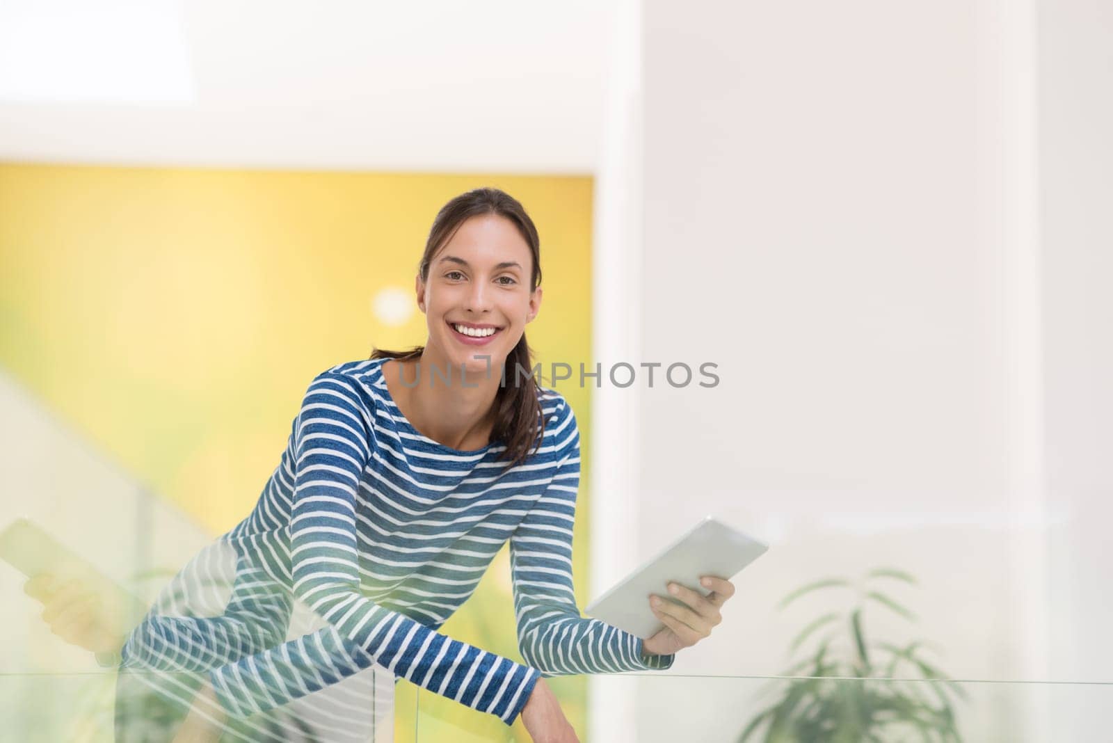 beautiful young woman at home websurfing on internet with tablet