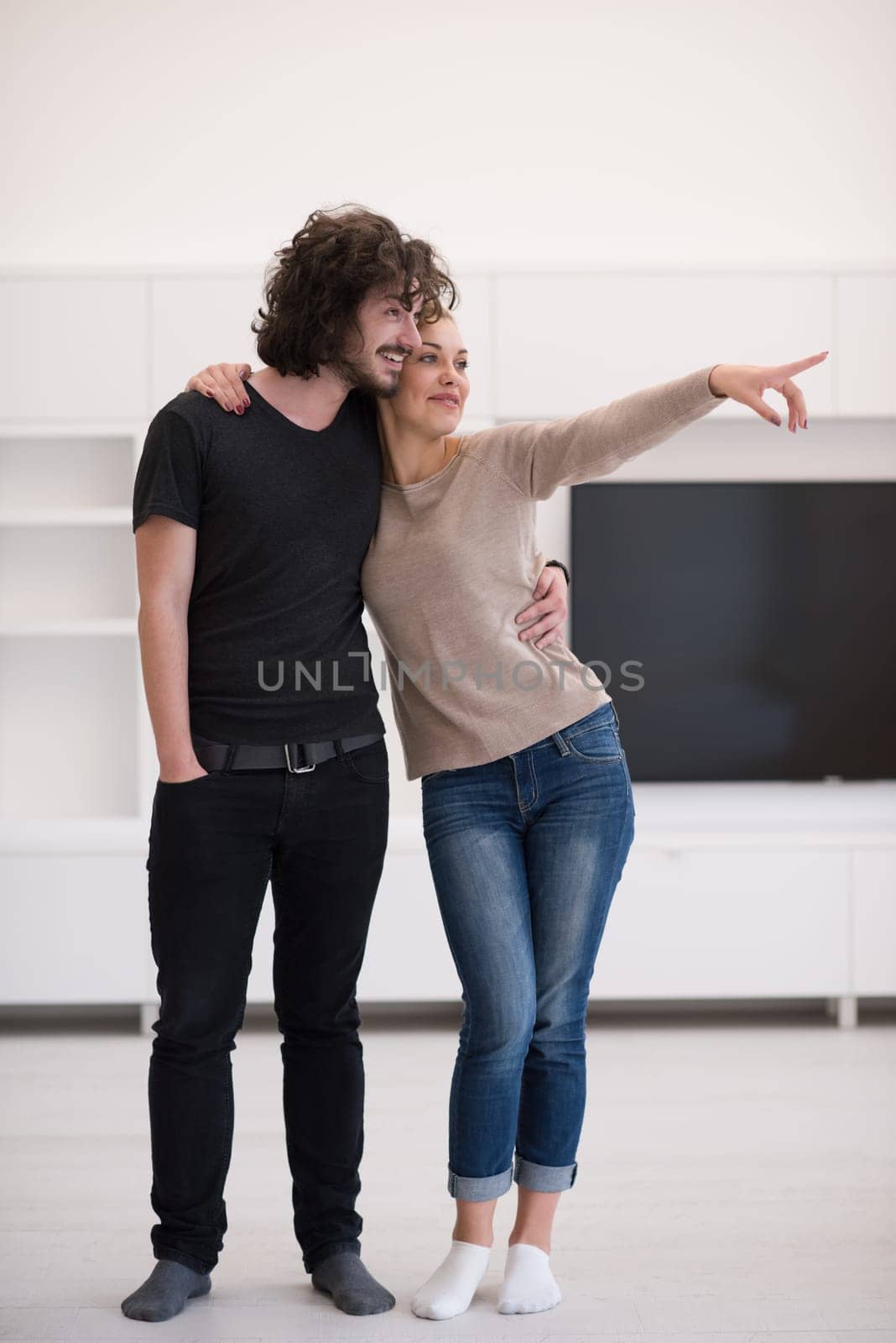 Portrait of a happy young beautiful couple hugging in their new home