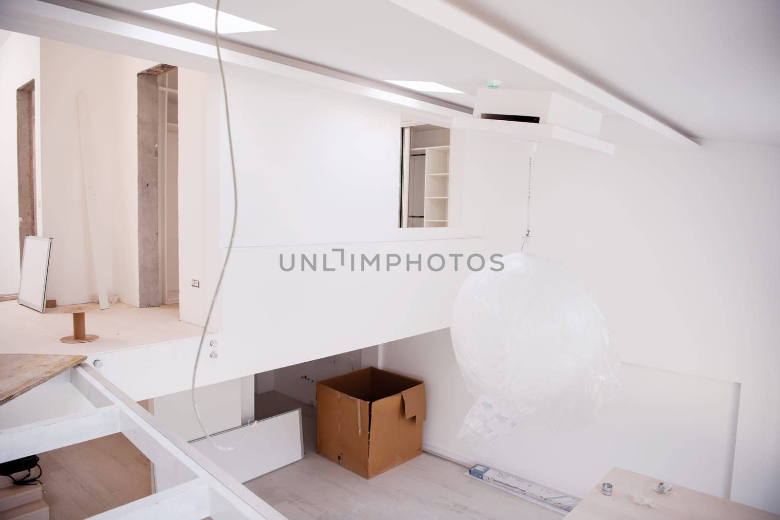 Interior of empty stylish modern open space two level apartment with white walls and large round chandelier in the middle ready to move in