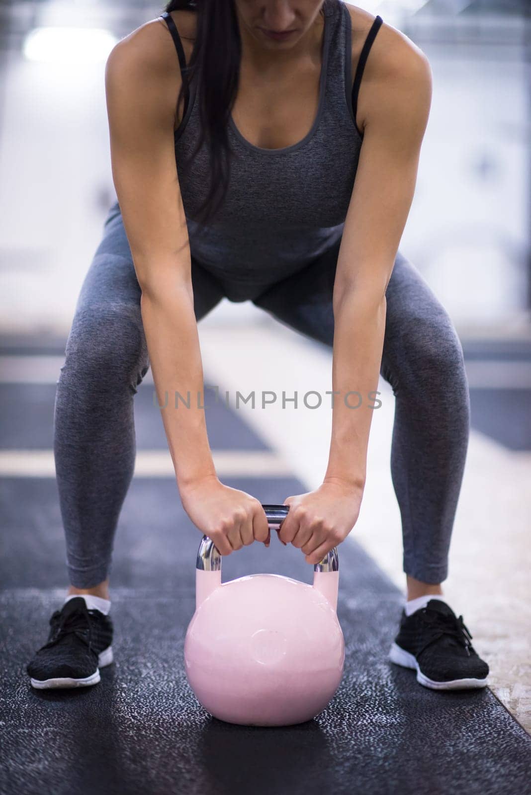 young  woman athlete exercise with fitness kettlebell at cross fitness gym