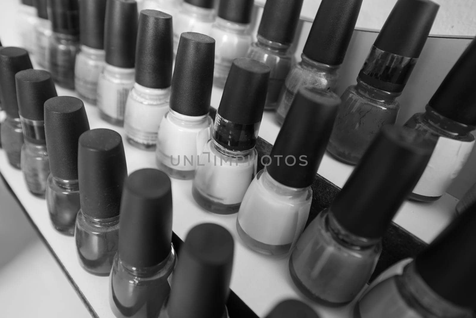 Set of different bottles of nail polish in the shelf in the beauty salon
