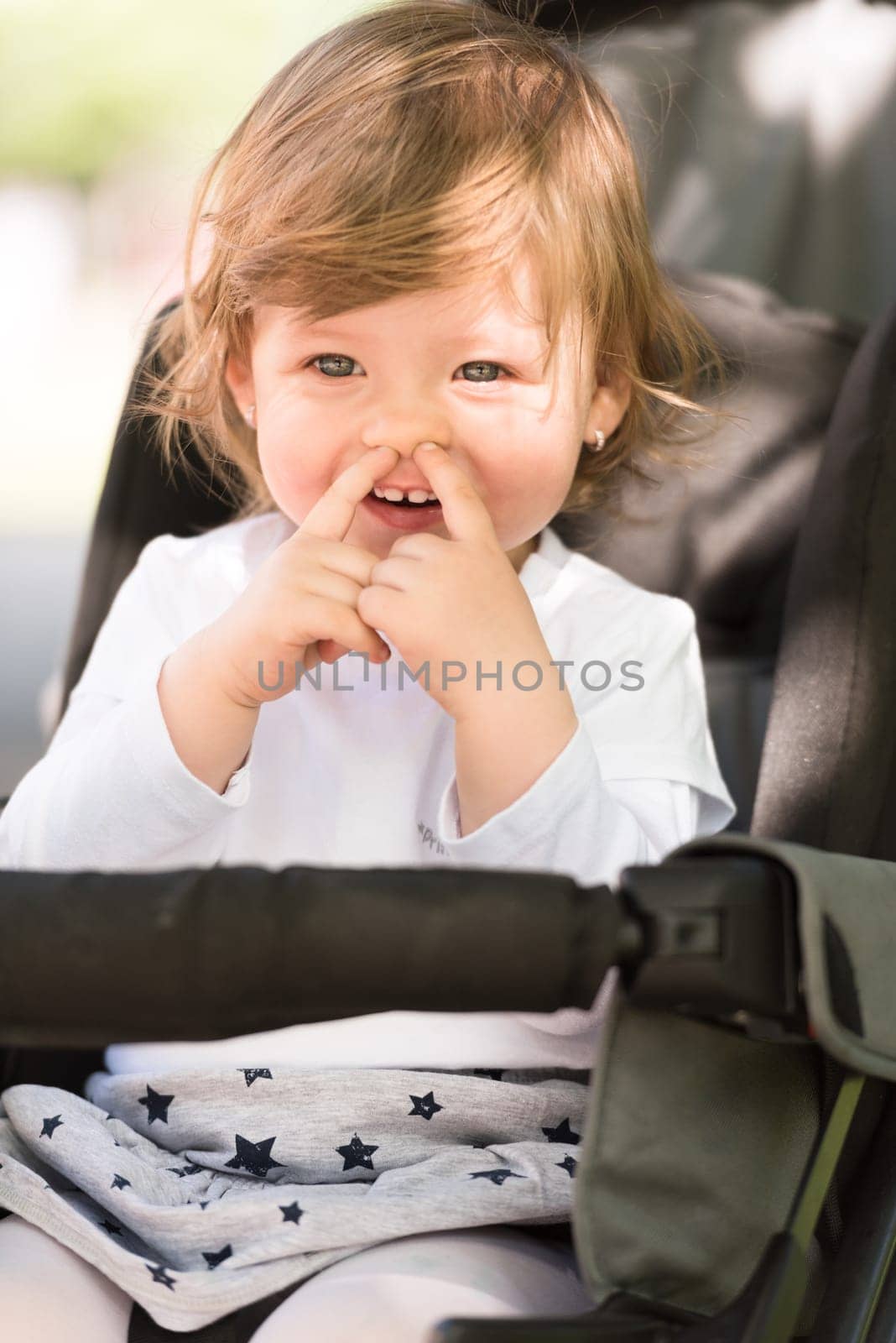 little and very beautiful baby girl sitting in the pram and waiting for mom