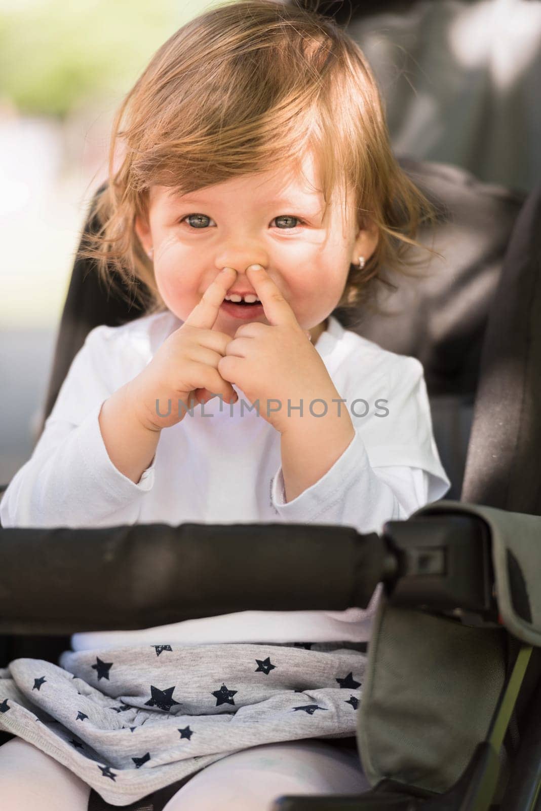 little and very beautiful baby girl sitting in the pram and waiting for mom