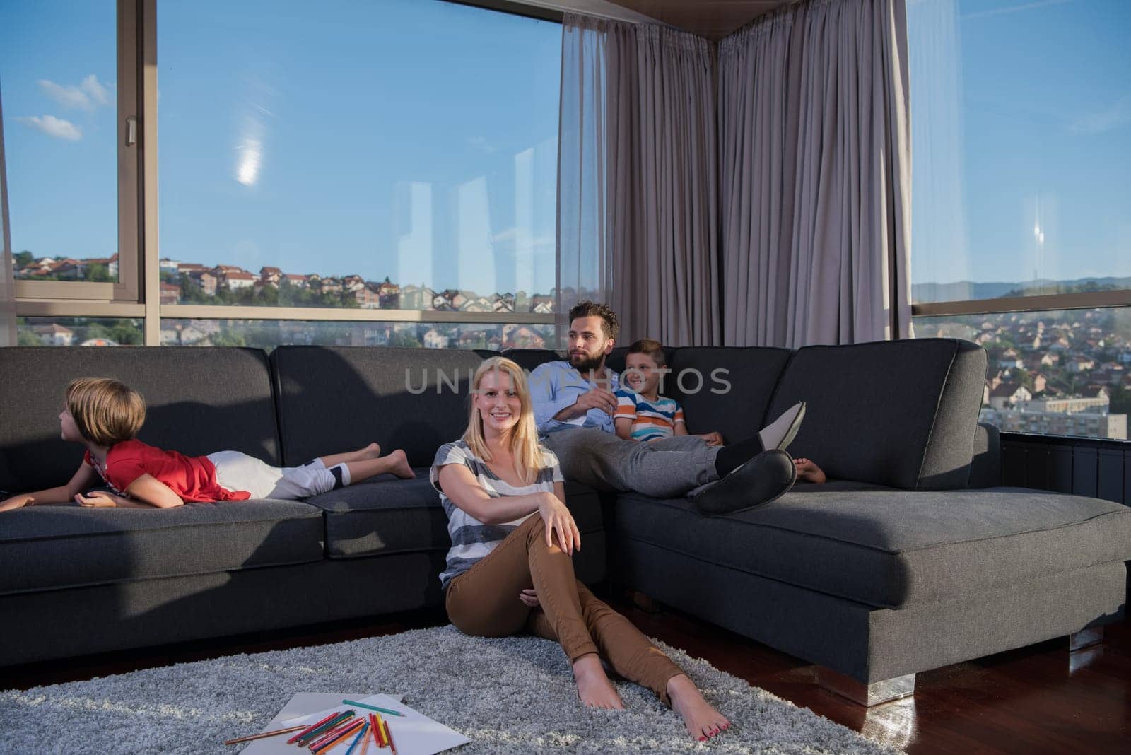 Happy Young Family Playing Together at home on the floor using a tablet and a children's drawing set