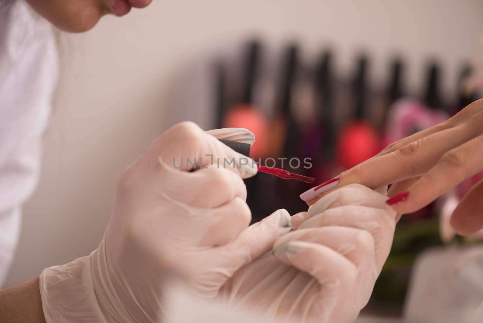 Woman hands receiving a manicure in beauty salon. Nail filing. Close up, selective focus.