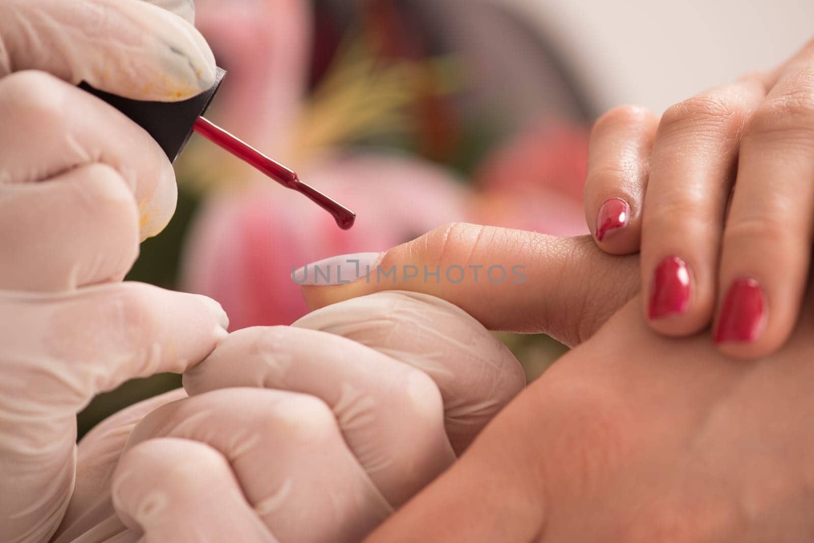 Woman hands receiving a manicure in beauty salon. Nail filing. Close up, selective focus.