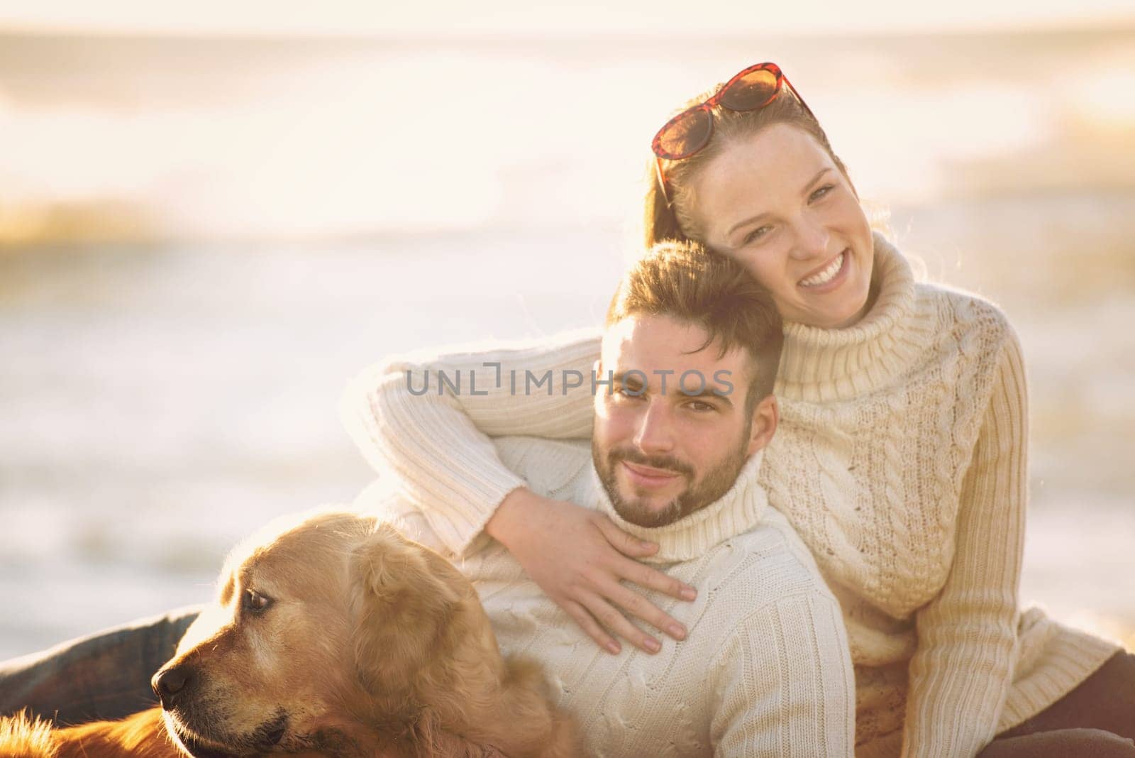 Couple With A Dog enjoying time  together On The Beach at autumn day