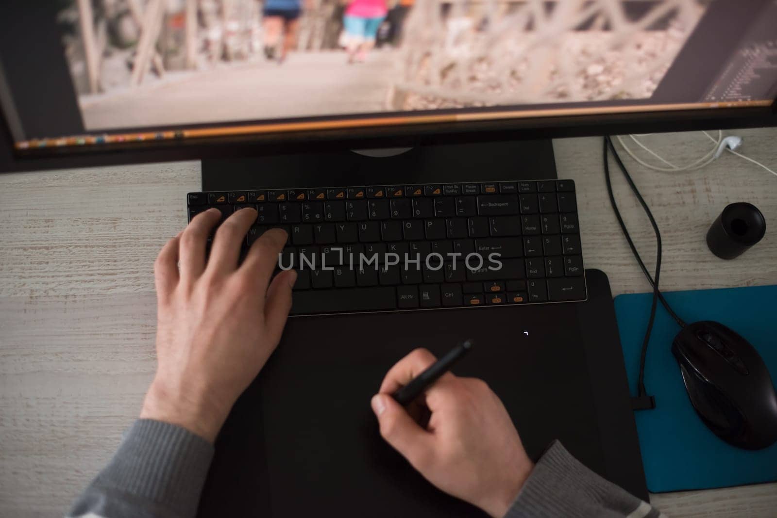 Young graphic designer working on a digital tablet and a computer top view