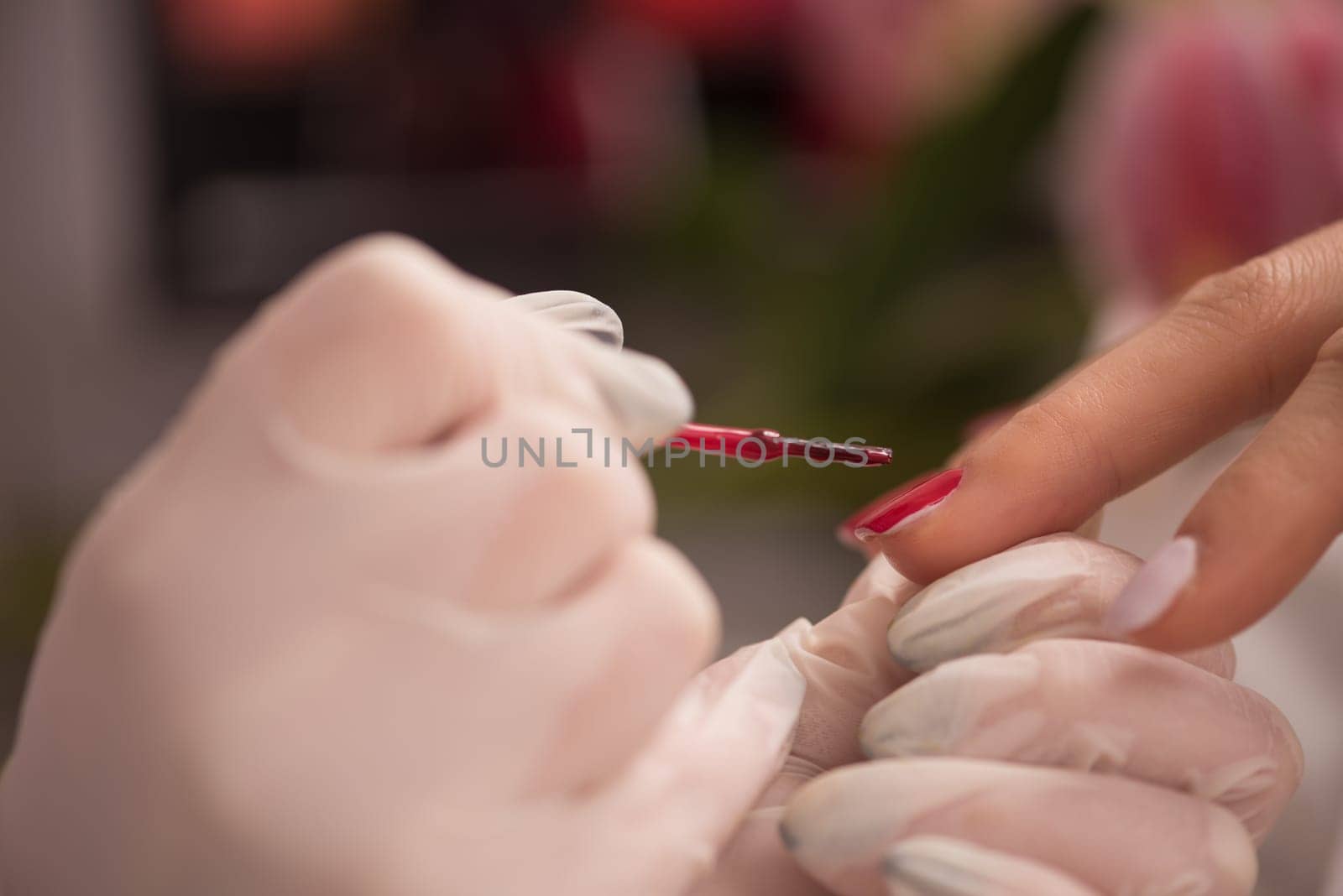 Woman hands receiving a manicure in beauty salon. Nail filing. Close up, selective focus.