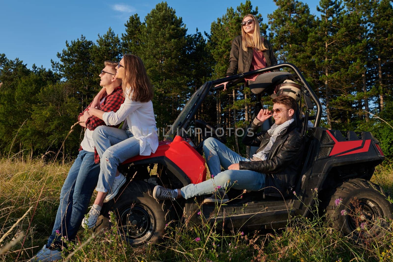 portrait of group young happy people enjoying beautiful sunny day while driving a off road buggy car on mountain nature