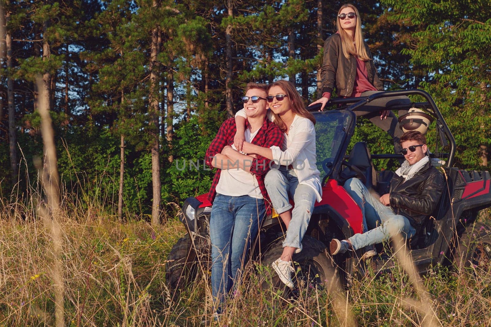 portrait of group young happy people enjoying beautiful sunny day while driving a off road buggy car on mountain nature