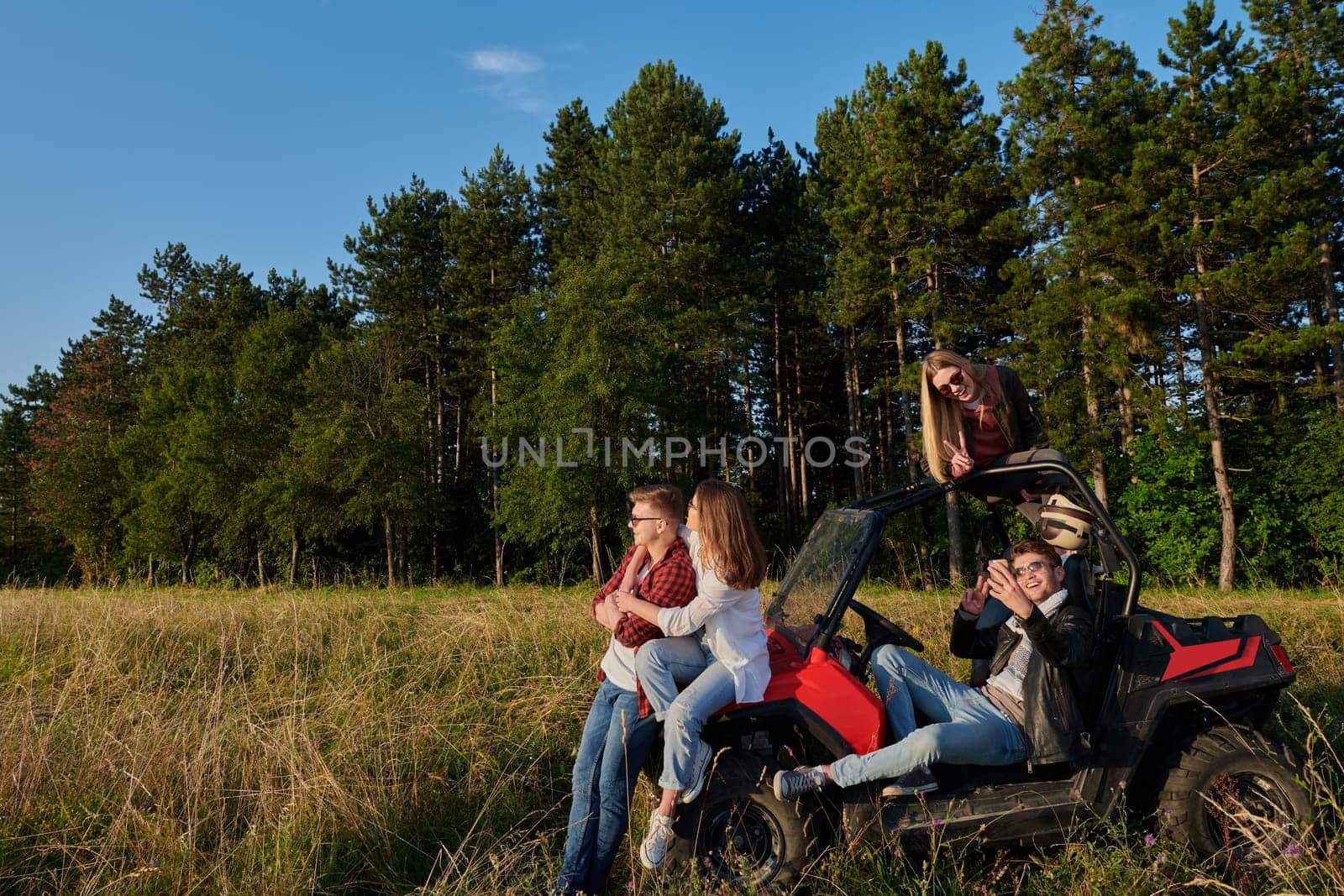 portrait of group young happy people enjoying beautiful sunny day while driving a off road buggy car on mountain nature
