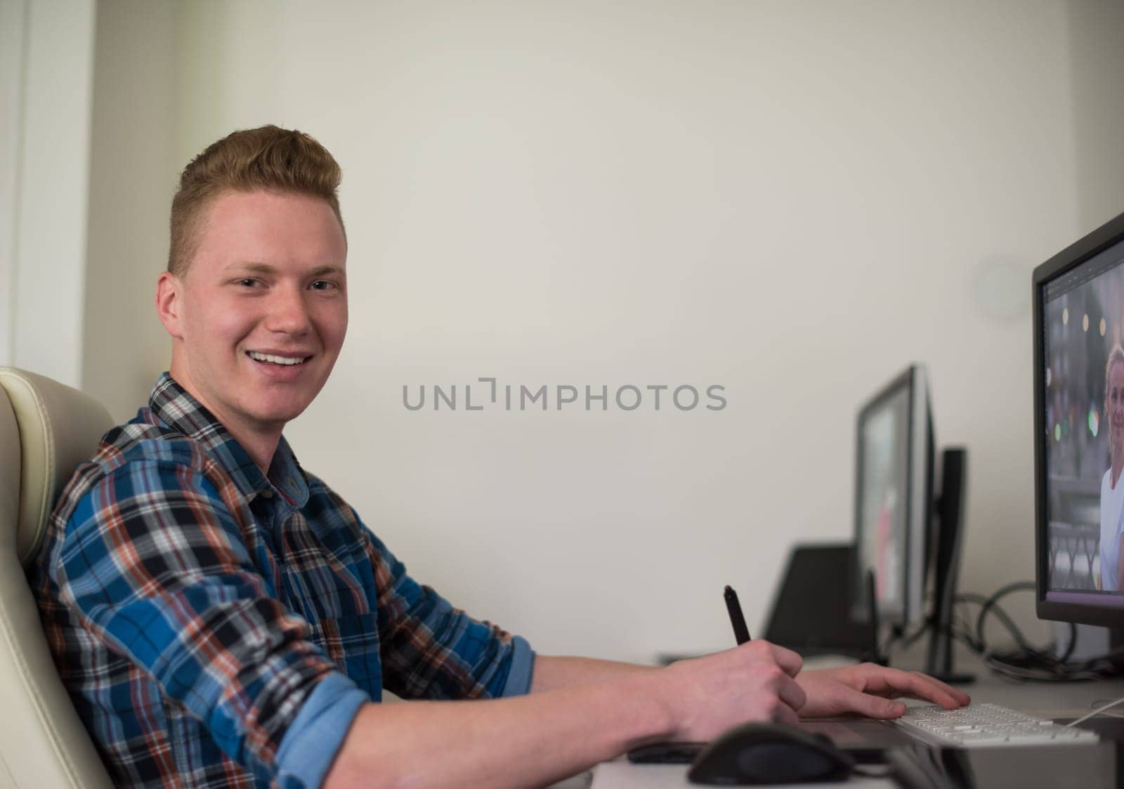 Young graphic designer working on a digital tablet and a computer