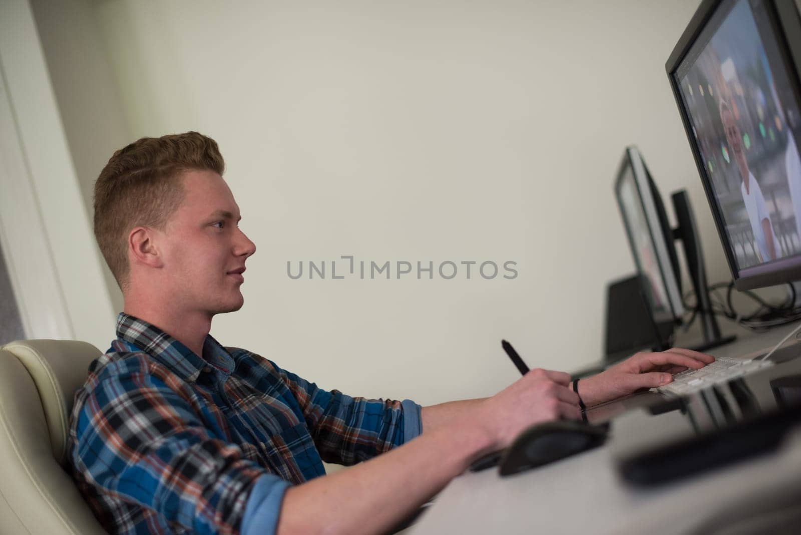 Young graphic designer working on a digital tablet and a computer